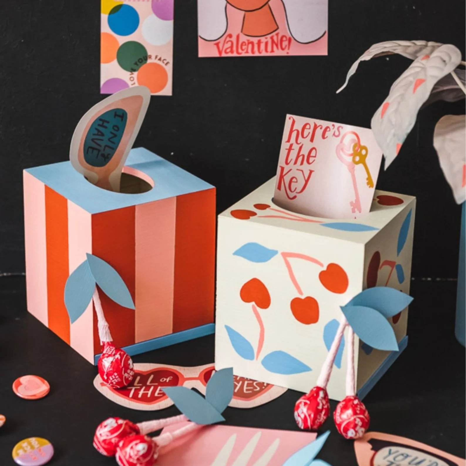 Painted tissue boxes on black background.