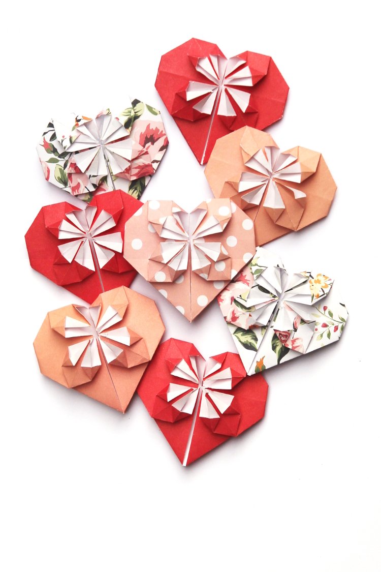 Origami hearts made out of red and peach patterned paper.