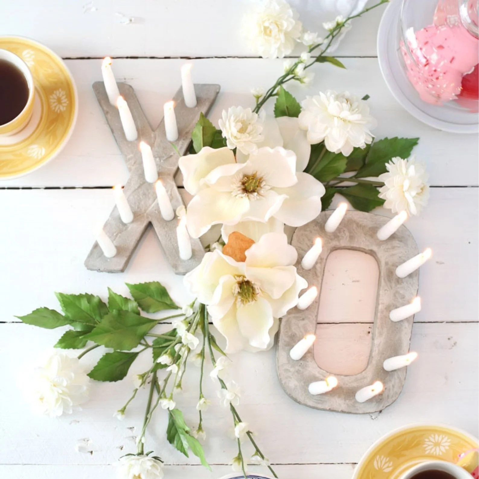 Concrete candle holders in the shapes of x and o.