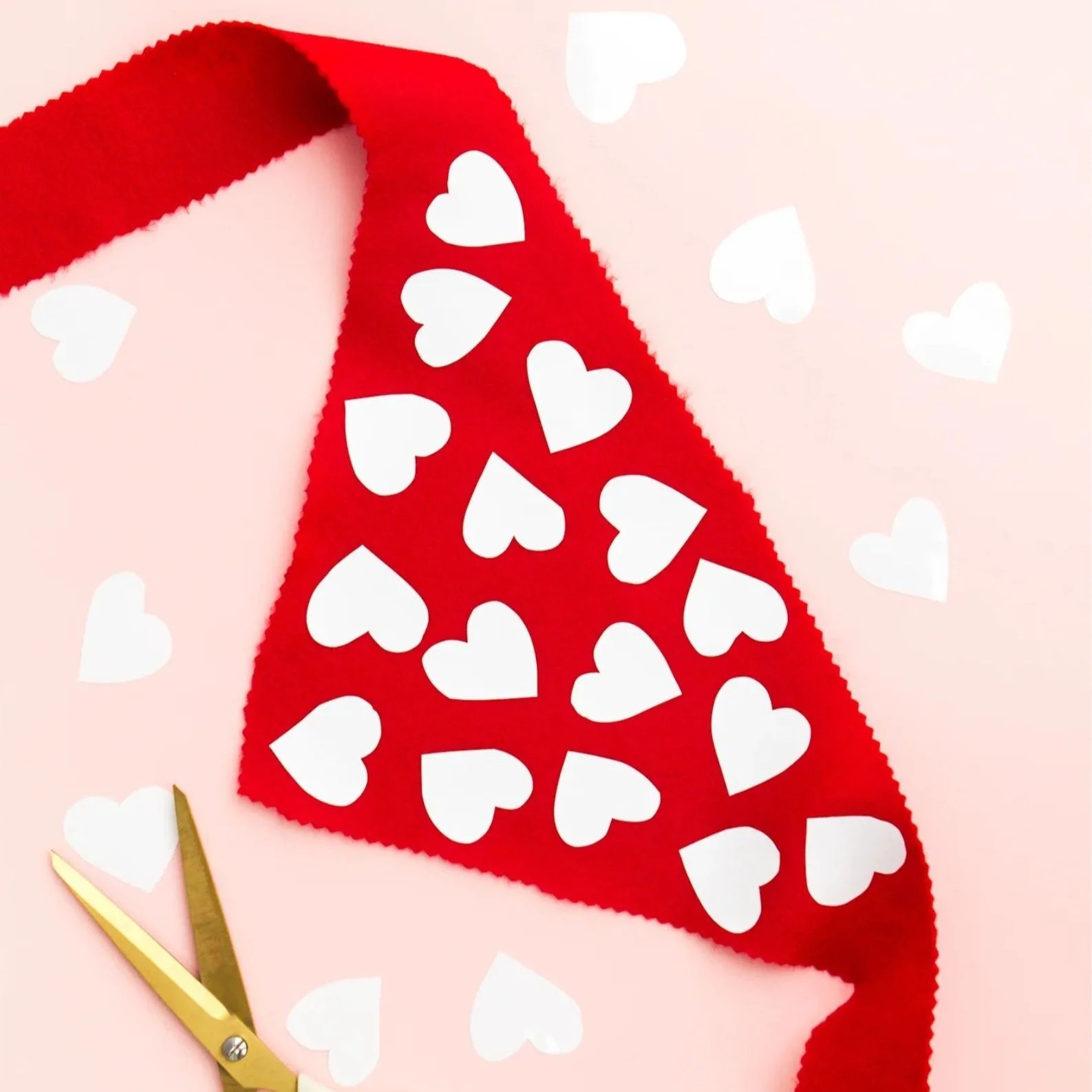 Red triangle shaped scarf covered in white hearts.