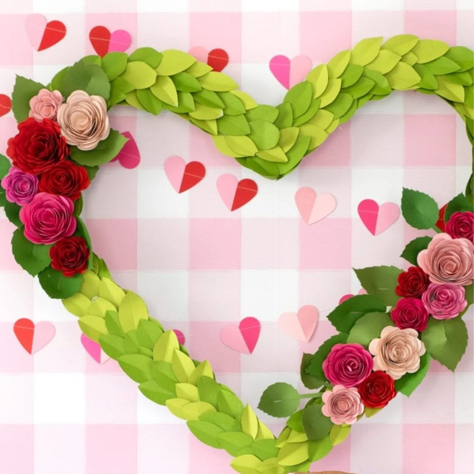 Heart shaped wreath made out of paper leaves and roses.