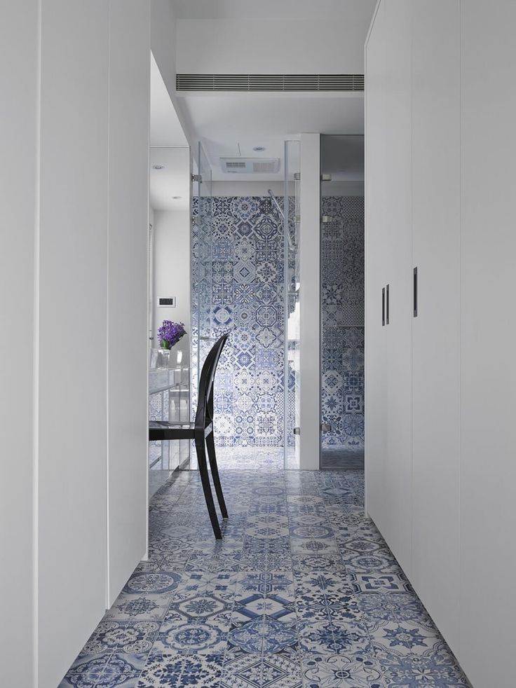 These blue and white tiles offer color, pattern and pop in contrast to the stark white walls and vanity area. Image via Home Adore. 