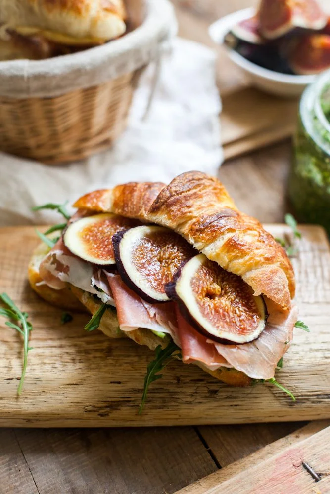 For those who likes sweet and savory, fresh figs and prosciutto, arugula and ricotta on a tender flaky croissant will delight and satisfy. Image via Relish Catering. 