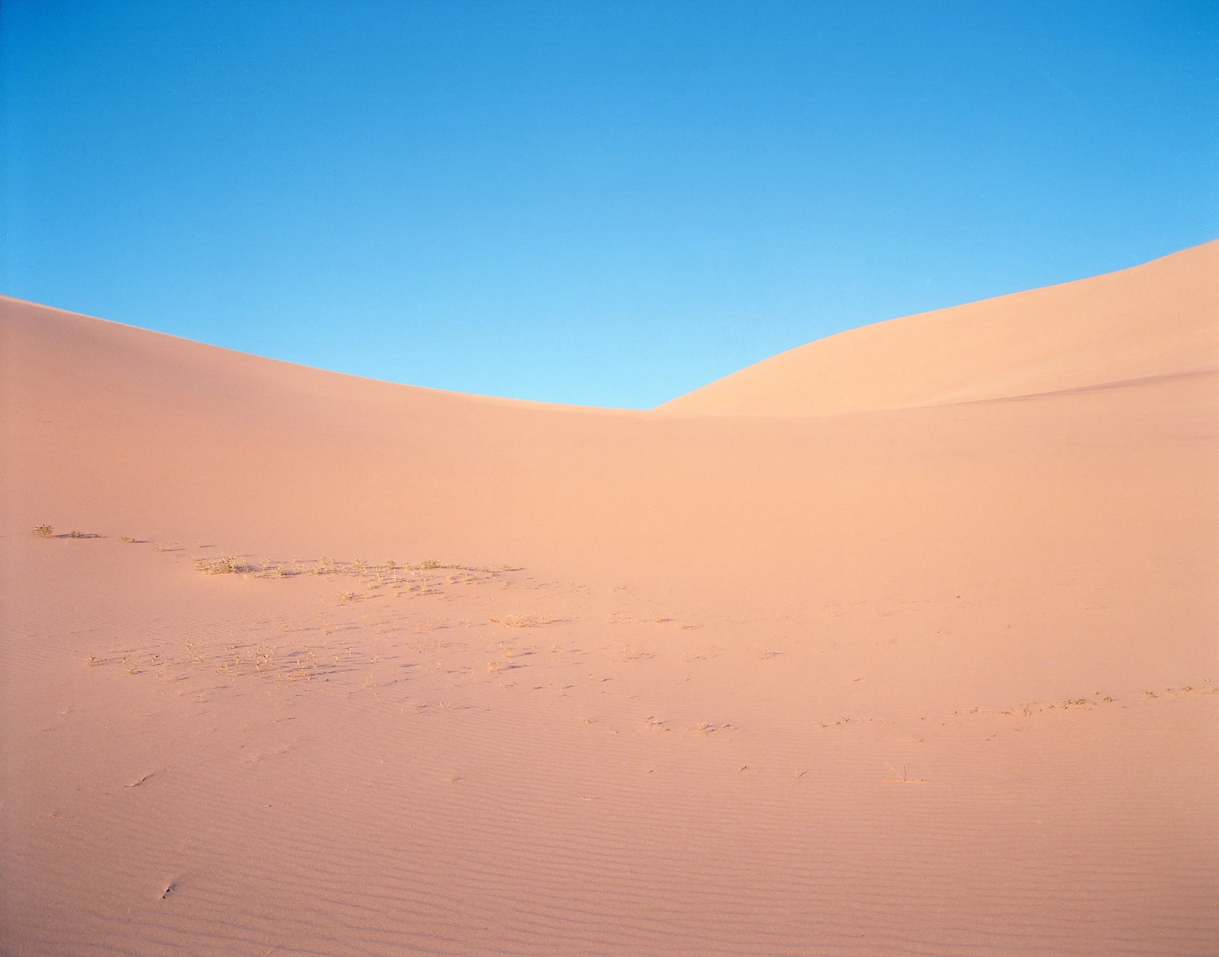 Eureka Sand Dunes right before Dusk, 2017. Pentax 6x7 + 55mm F/4. A late afternoon hike into these massive dunes was met with harsh sand blasting winds. Scared for the well being of the big pentax I was intending to not remove it from it's protective bag. After clearing the apex of a dune we came to this small valley which was calm and shield from the wind allowing me to take a few shots with the 6x7.
