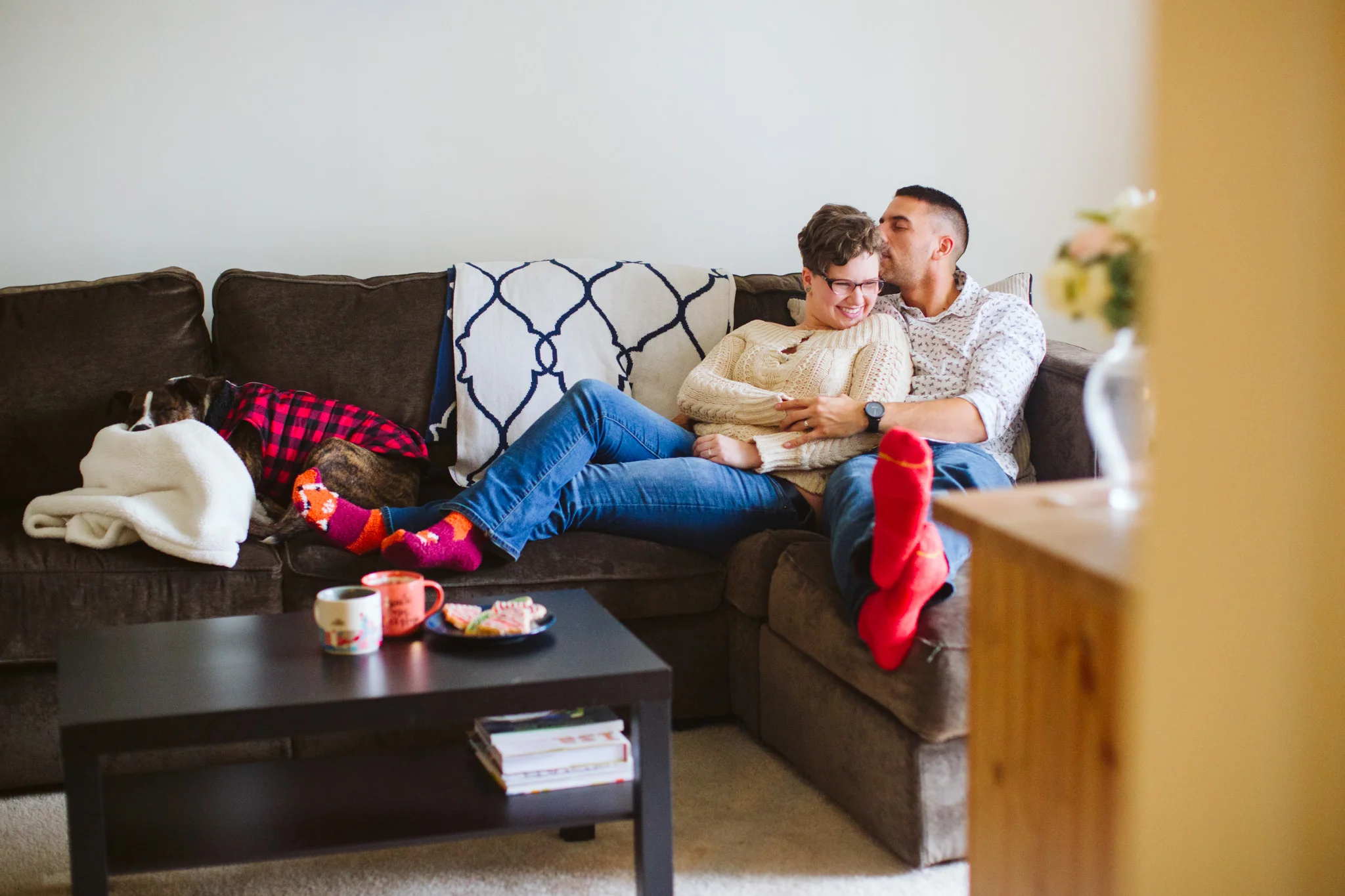 Couple cuddling on couch during in home lifestyle session