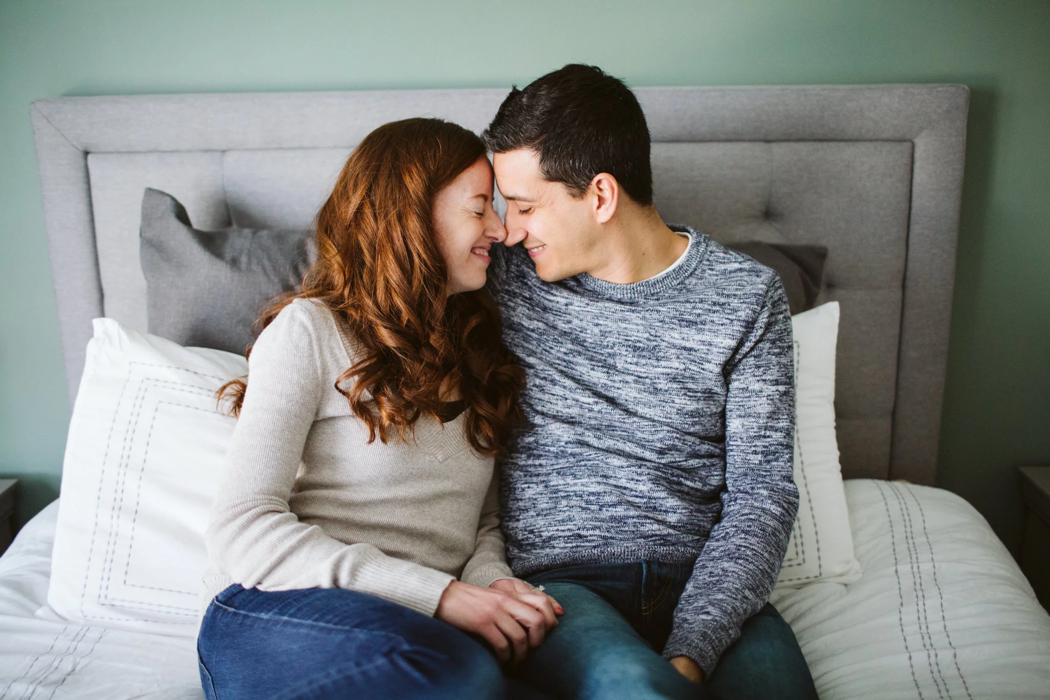 Couple cuddling on bed during lifestyle photography session
