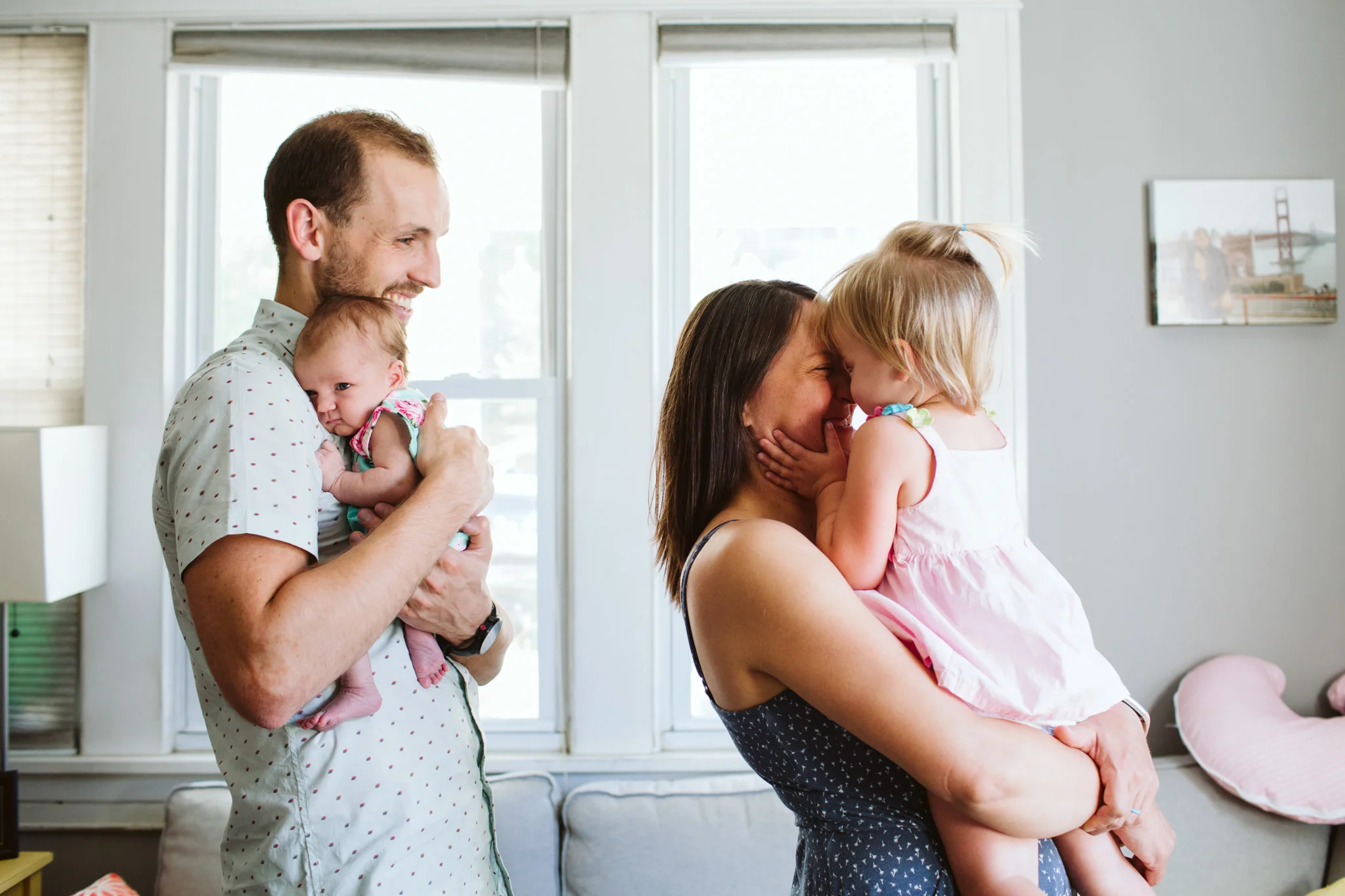 Parents holding baby and toddler in living room lifestyle session