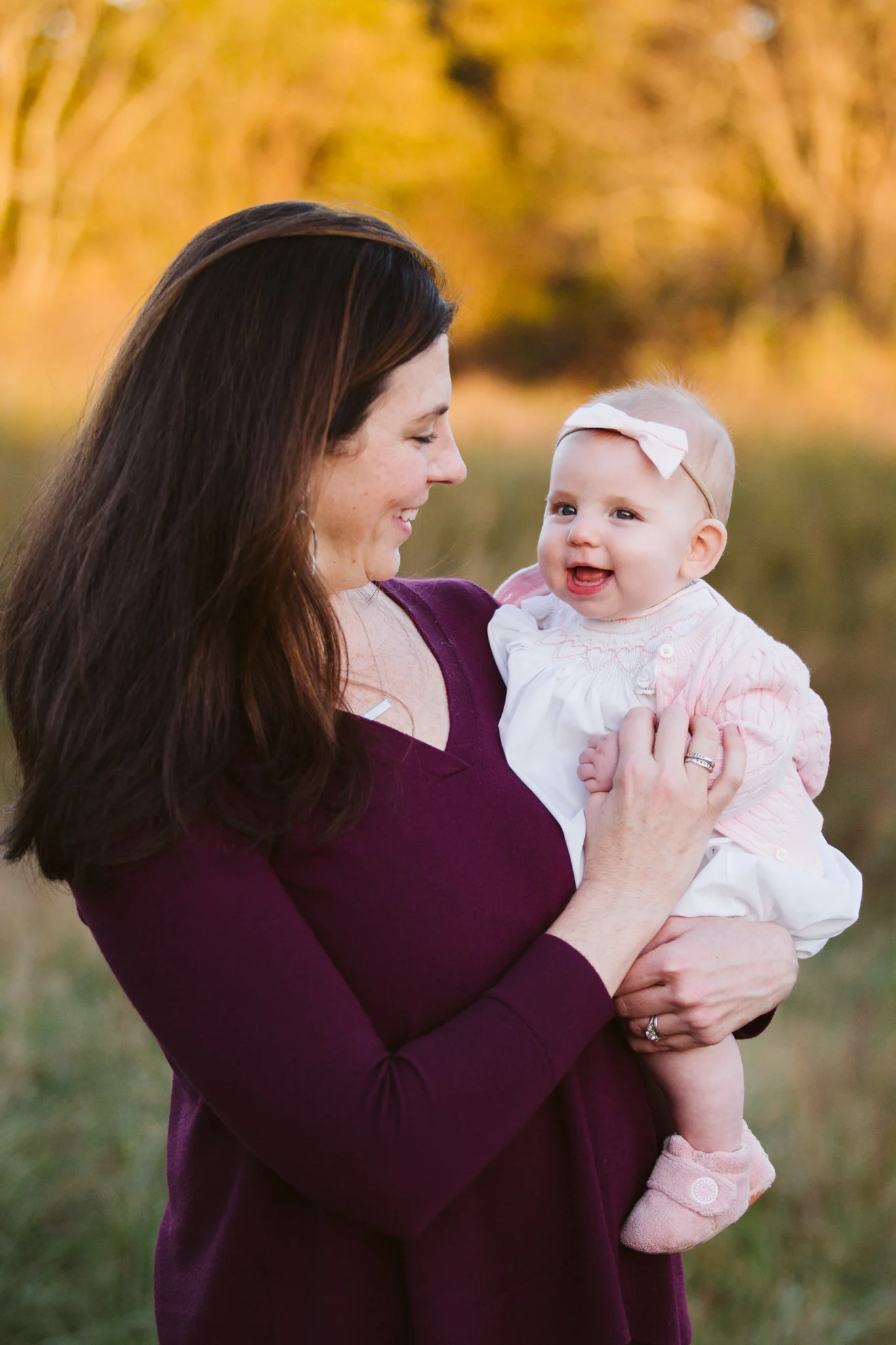 Mom holding little girl outside at family photography session