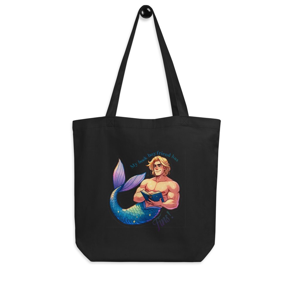 Black medium cotton tote bag with merman illustration graphic and text "My book boyfriend has fins!" hanging on a knob.