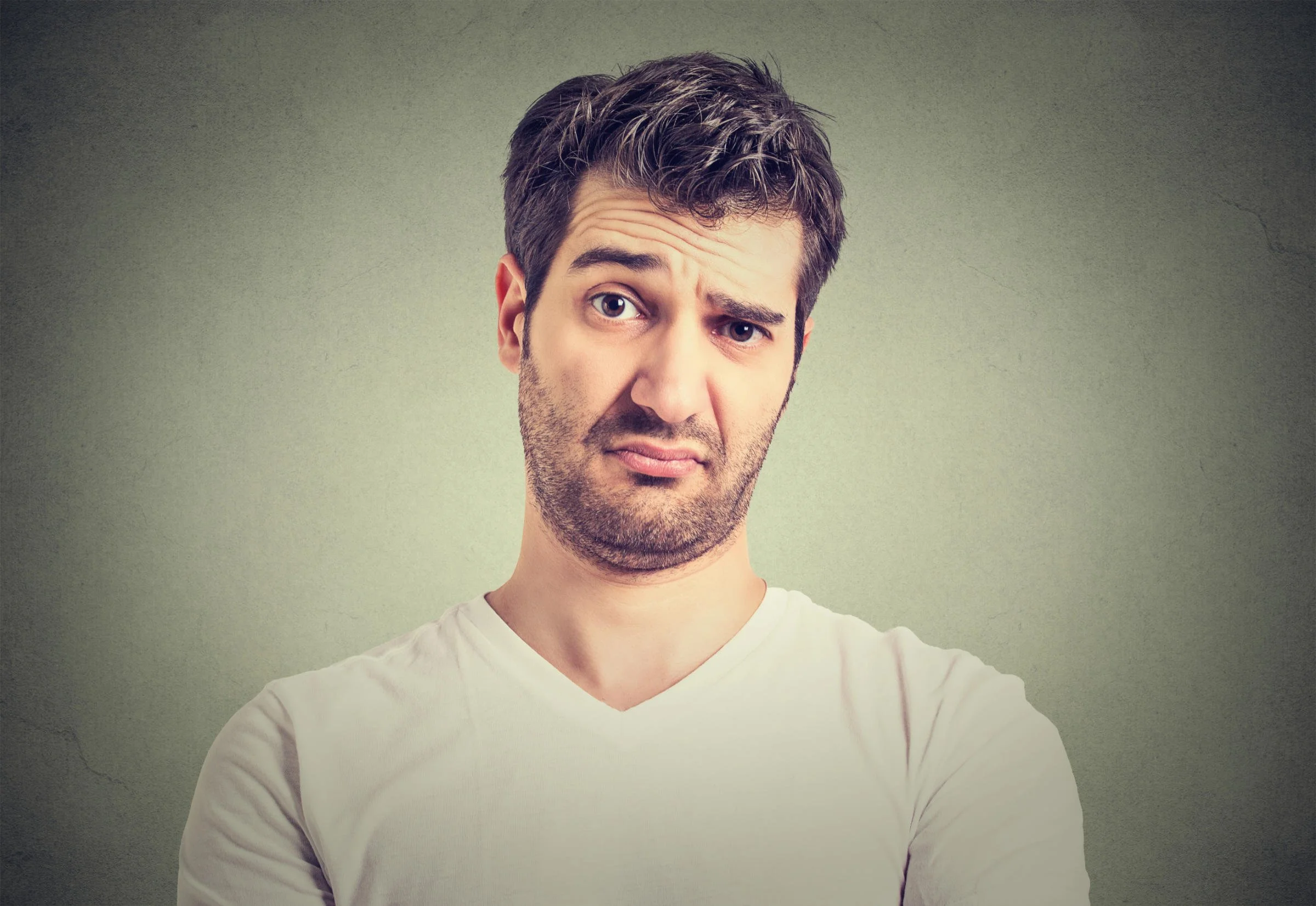 A man raises one eyebrow, looking skeptical.