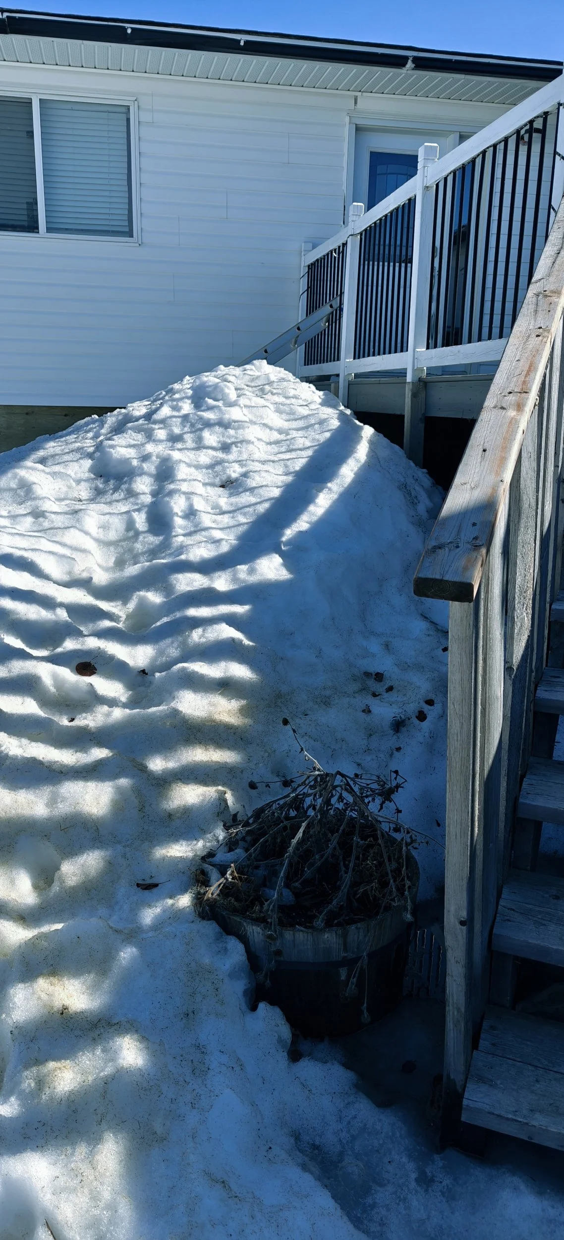 Piled snow next to a deck.
