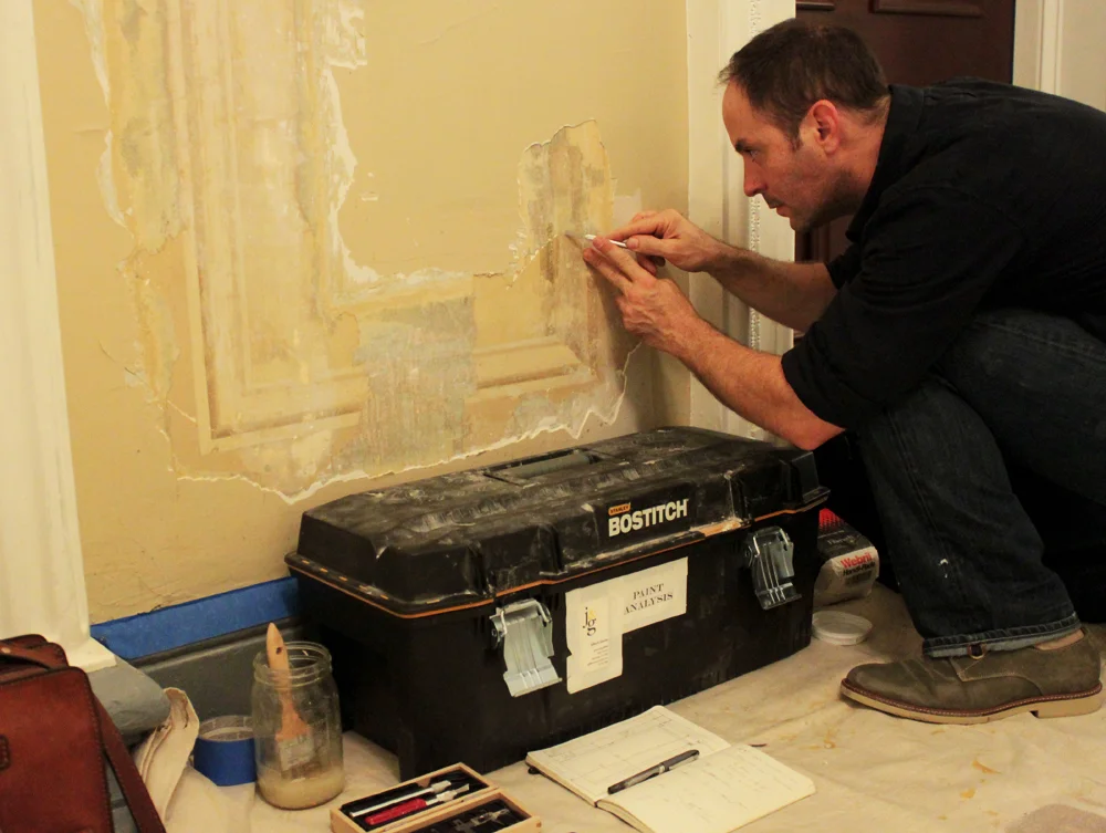 Exposing sections of the original trompe l`oeil painting with a combination of chemical and mechanical over-paint removal.