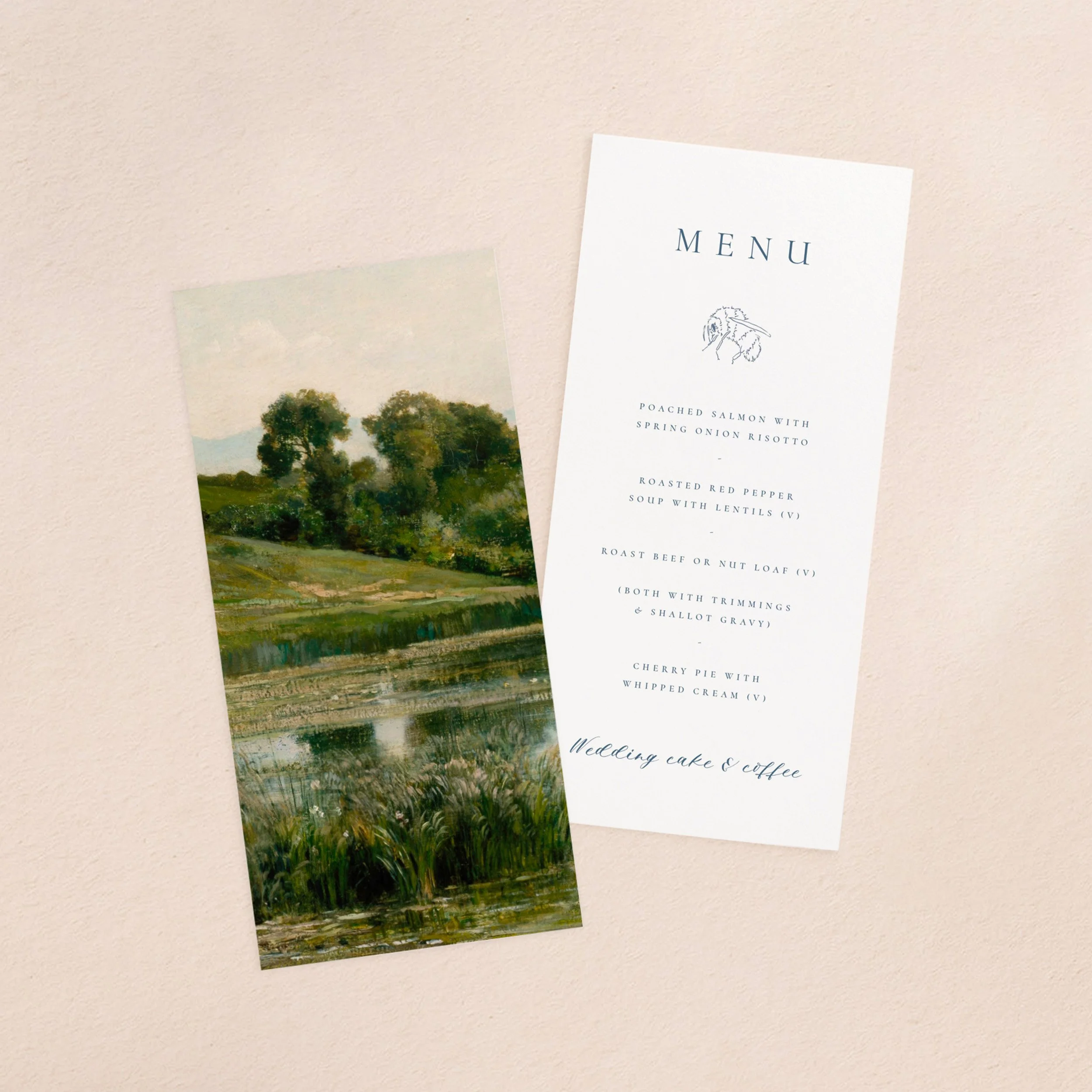 A wedding menu card and vellum paper overlay sheet printed with a lush green landscape with a pond in the foreground