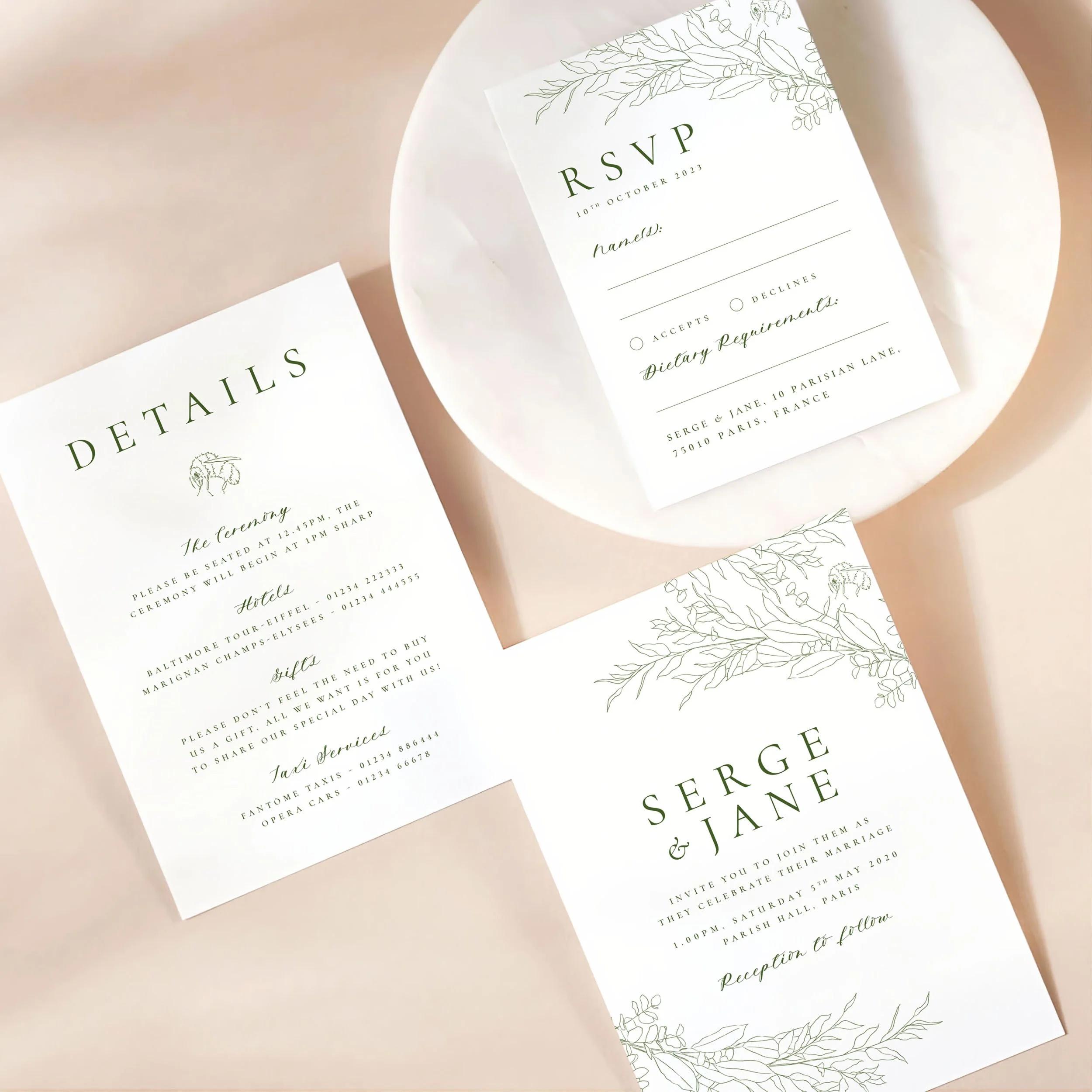 A wedding invitation card with details card and rsvp on a marble dish. There is a modern leafy motif design on each card.