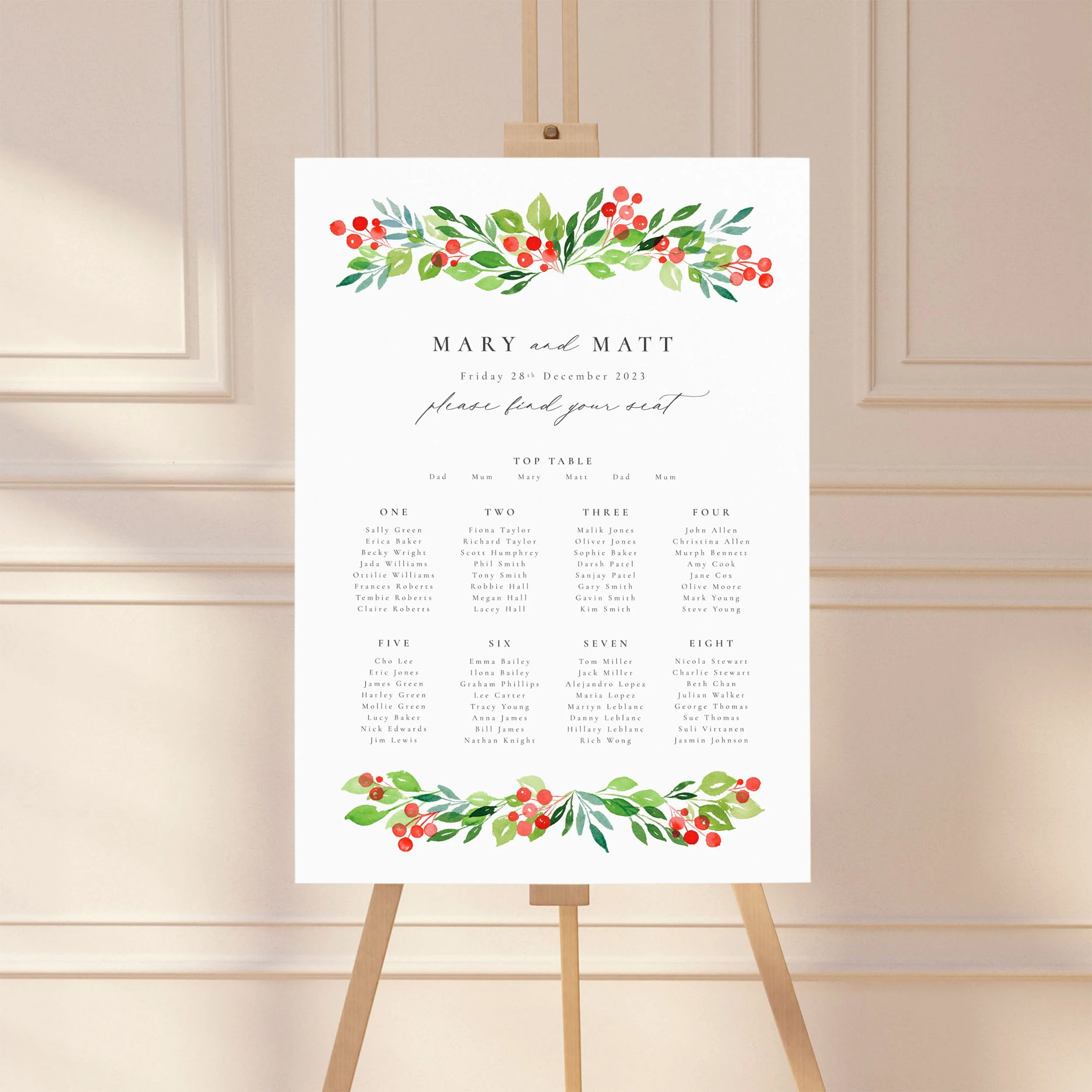 A wedding table plan sign printed on a large A1 board, standing on an easel. The design has watercolour green leaves and red winter berries.