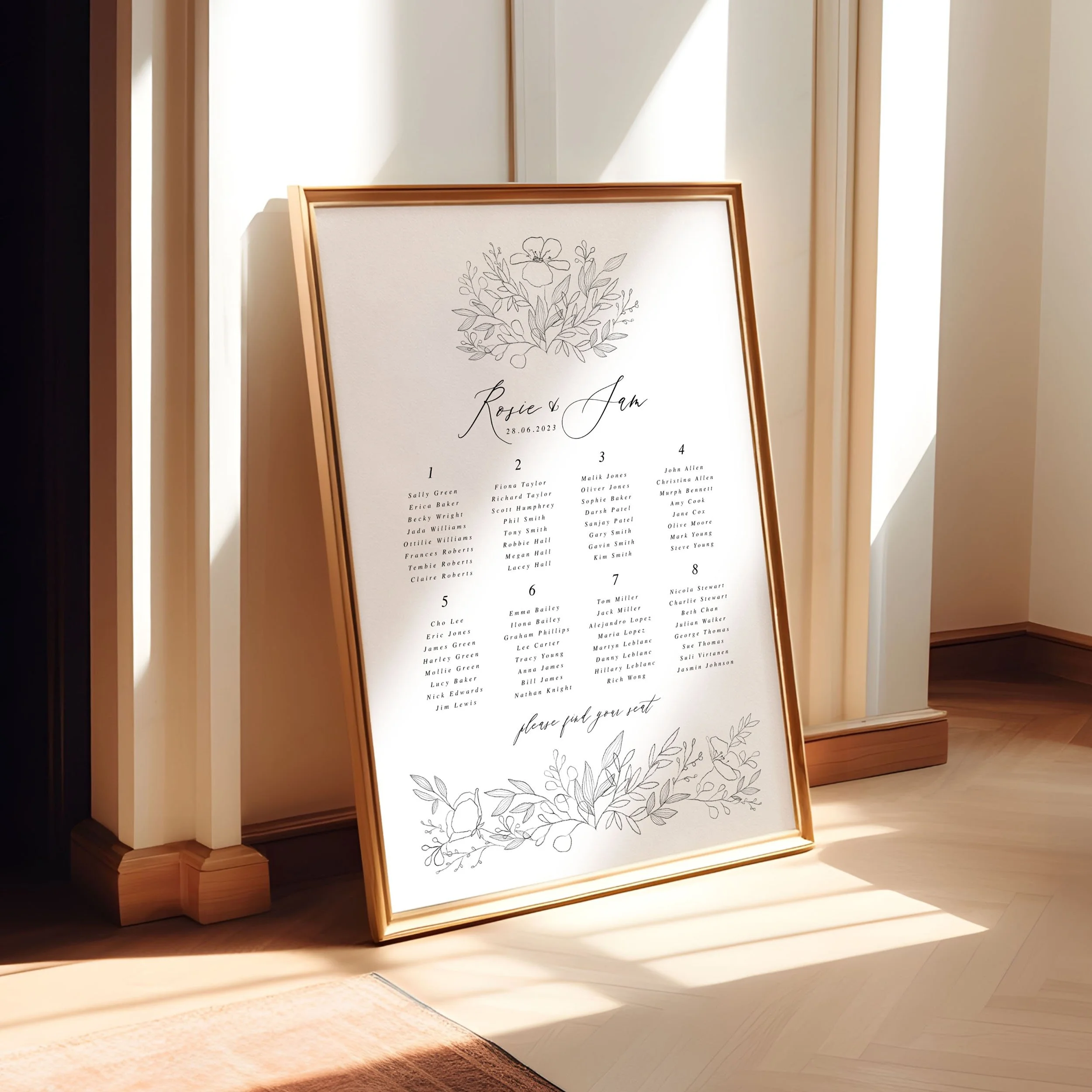 A framed A1 table plan sign leaning against a wall as the light spills across. The design has delicate flowers in a sketchy style.