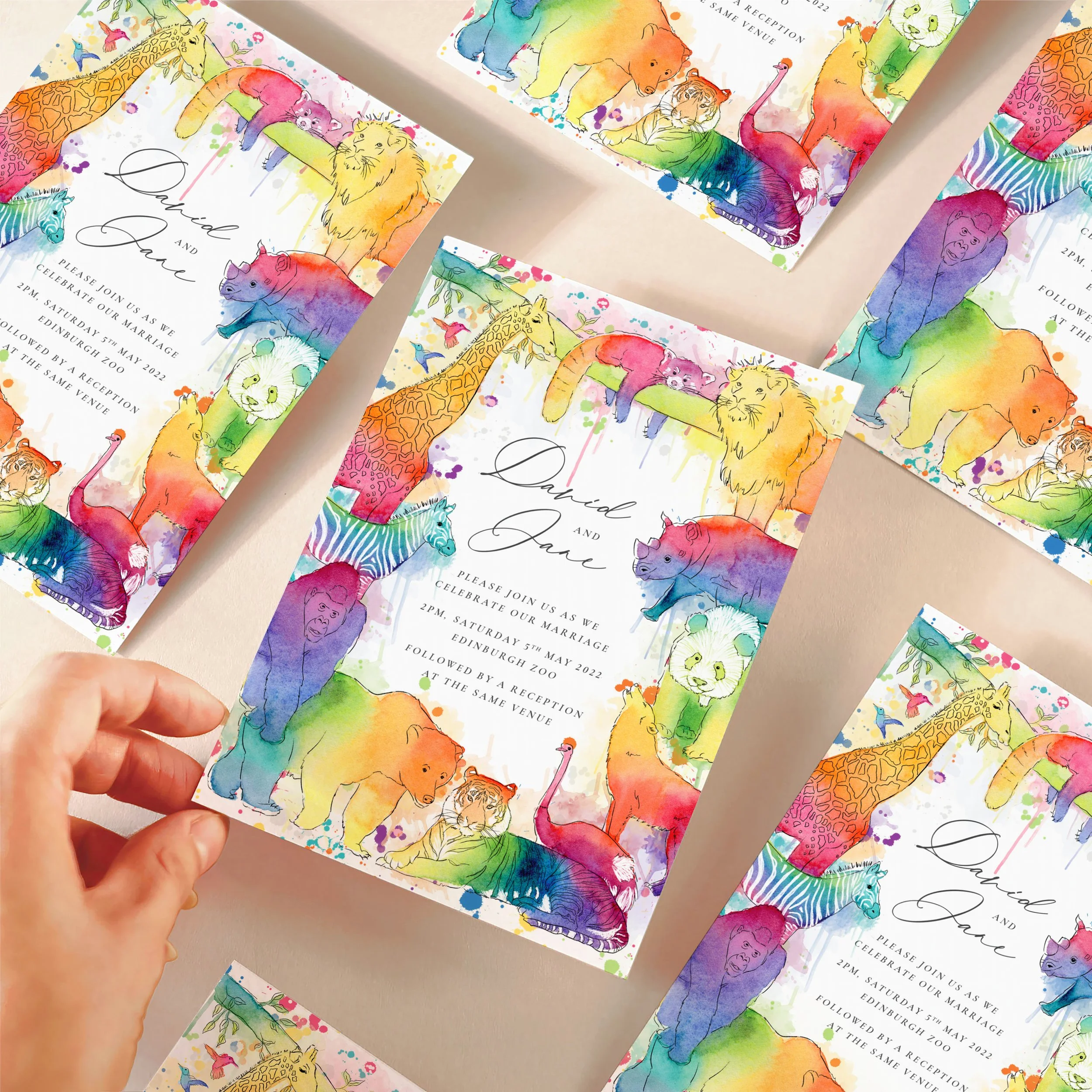 Colourful animal themed wedding invitations laid out on a table