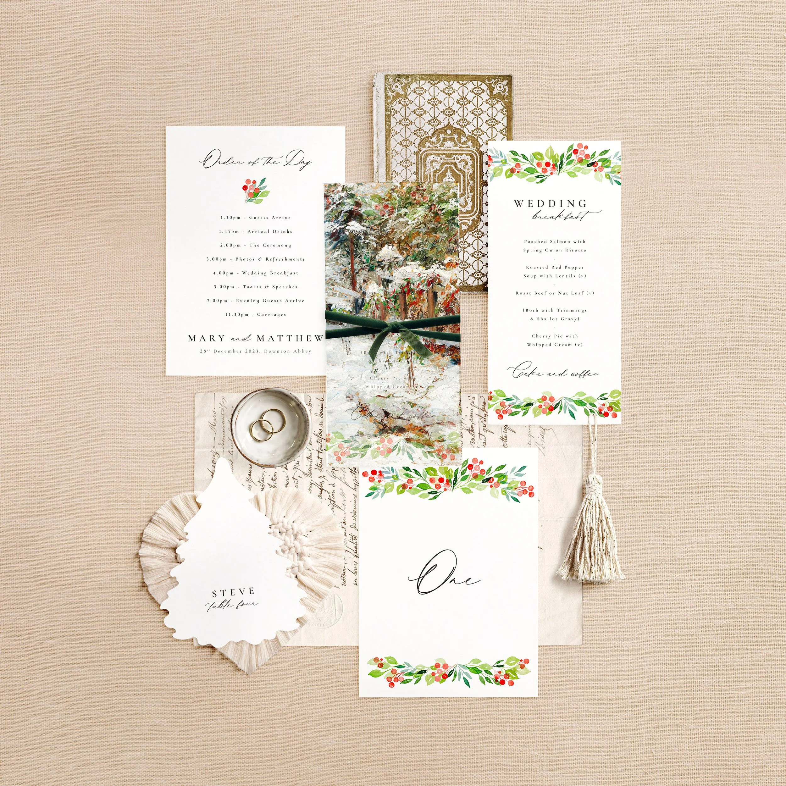 Wedding stationery flat lay featuring a menu, table number, order of the day and a Christmas tree shaped place card. A red and green wintery design.