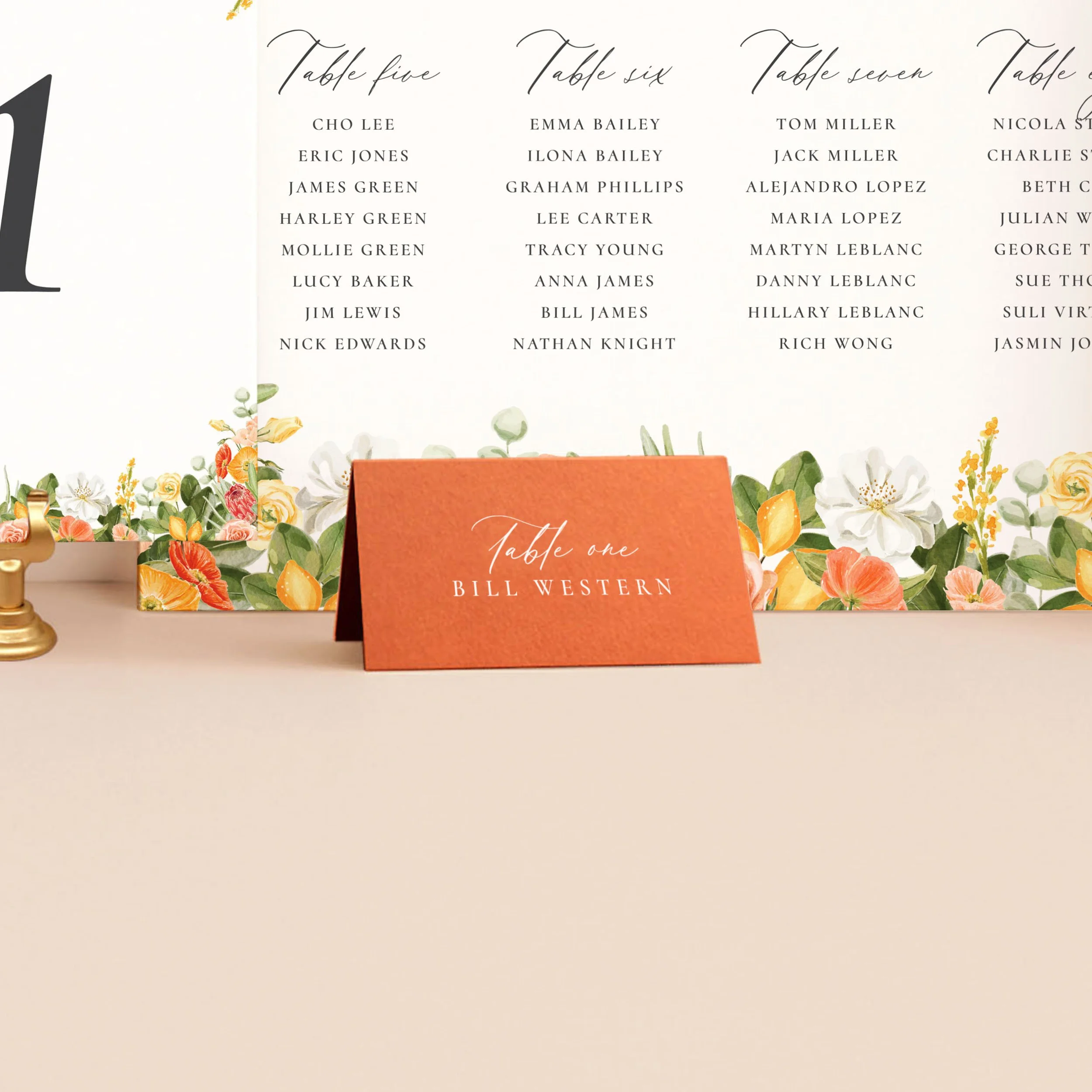 A bright orange tent place card, printed in white ink with a guest name.