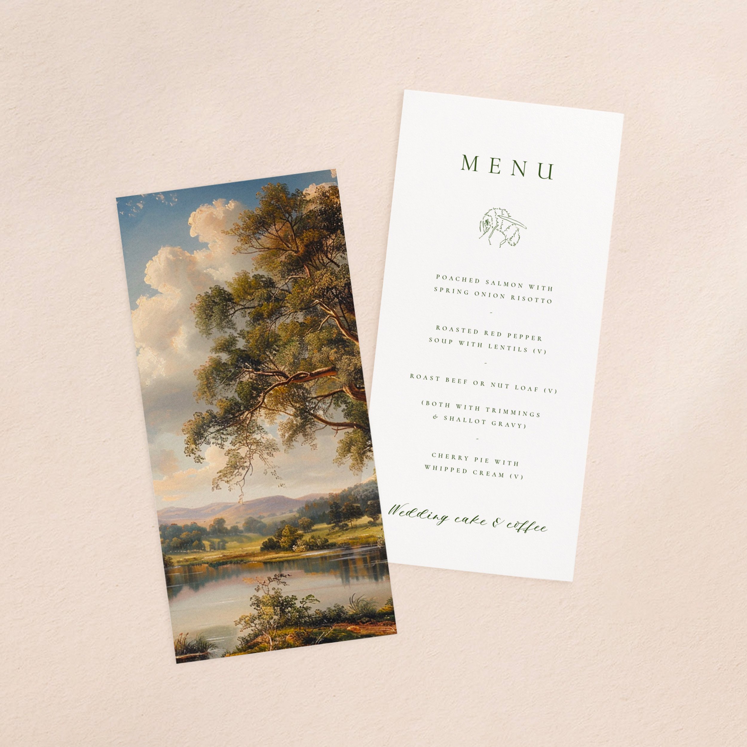 A wedding menu card and vellum paper overlay sheet printed with a lush green landscape with a lake in the foreground