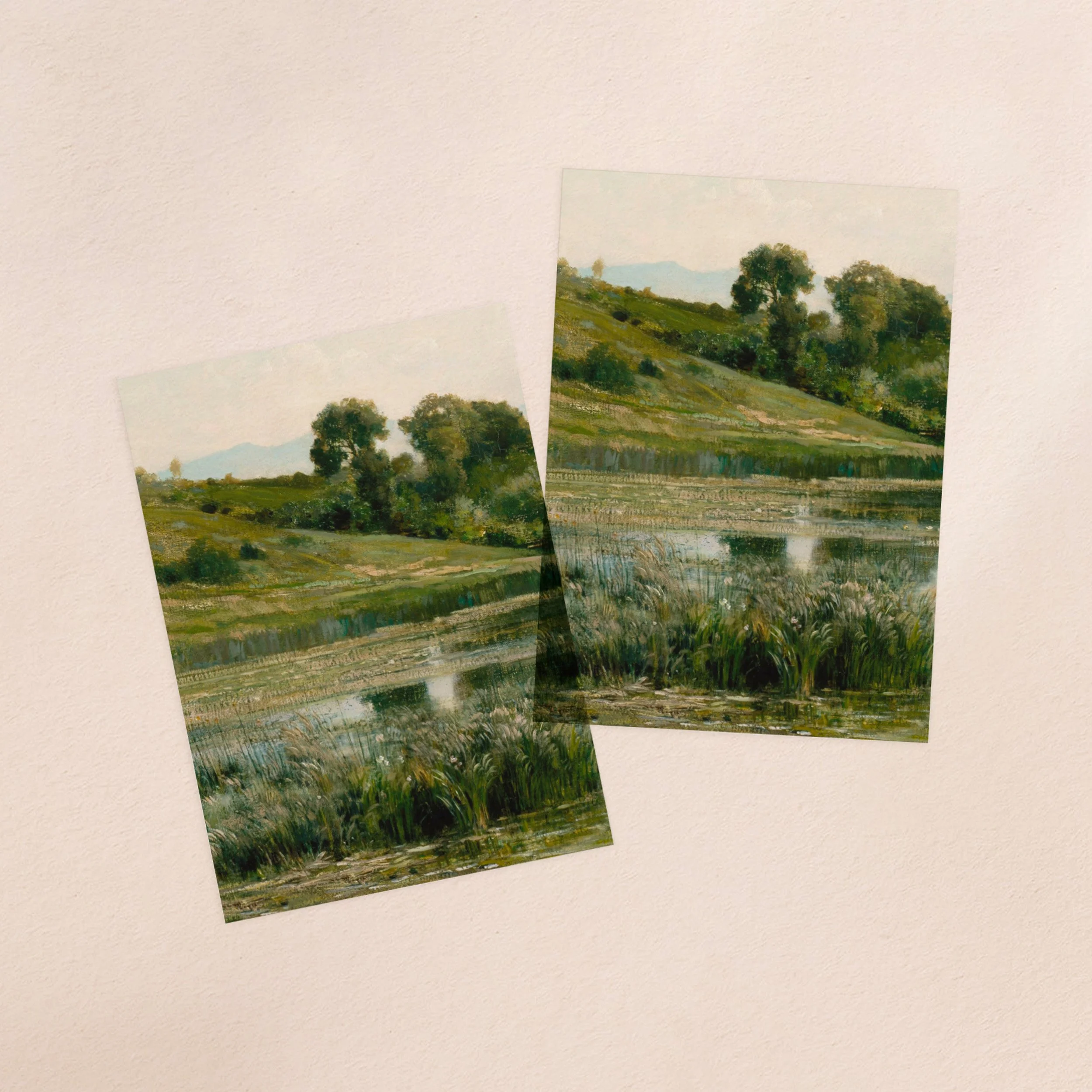 Two vellum paper overlay sheets printed with a lush green landscape with a pond in the foreground