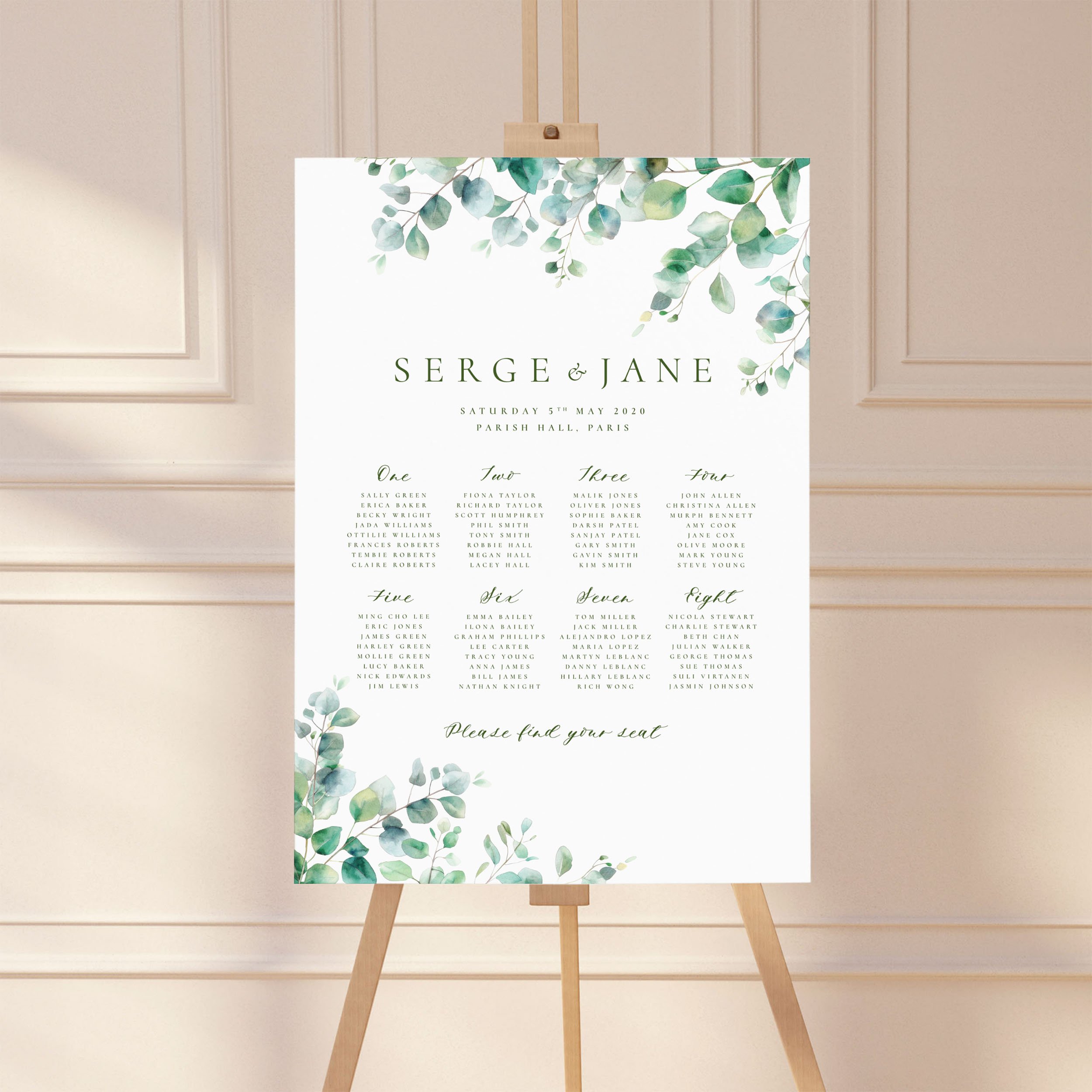 A wedding table plan sign printed on a large A1 board, standing on an easel. The design has watercolour eucalyptus leaves.