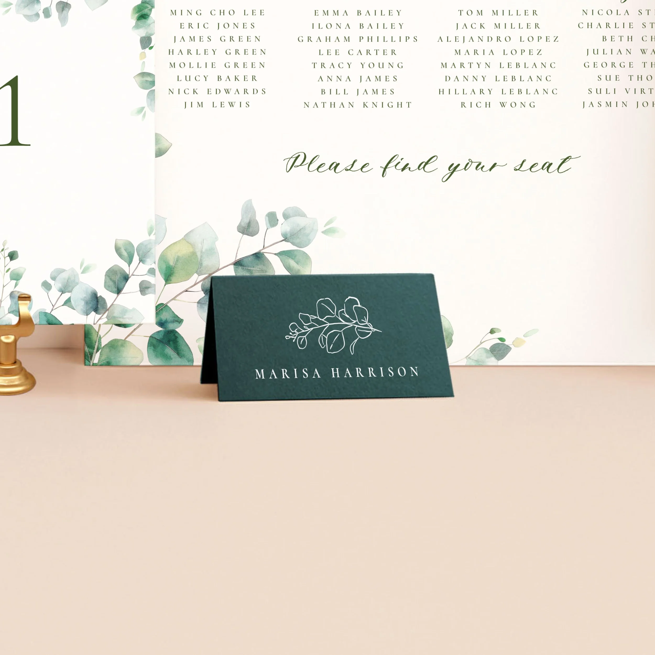 A dark green tent place card, printed in white ink with a guest name and a eucalyptus sprig illustration.