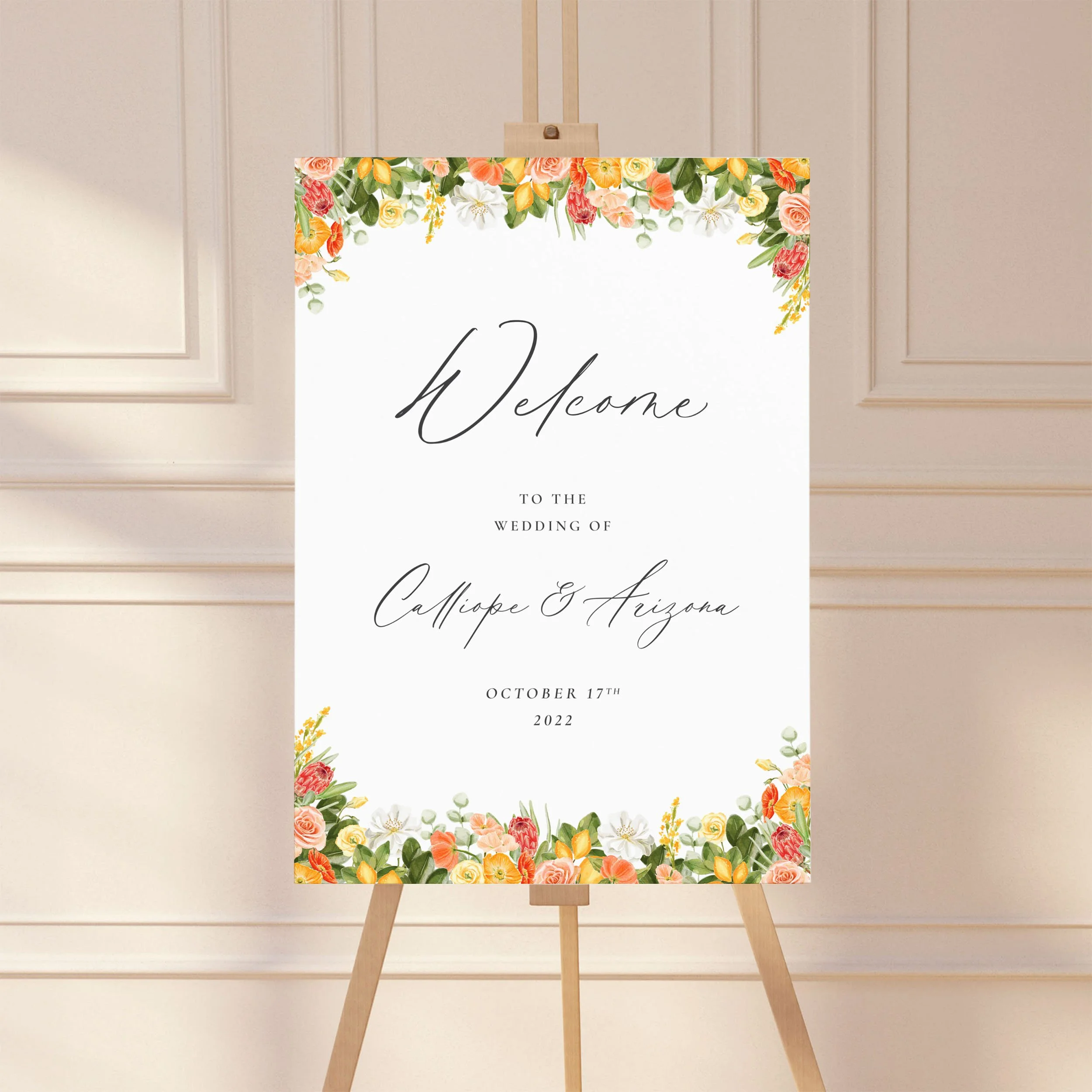 A large wedding welcome sign on an easel with a bright, summery yellow and orange floral design.