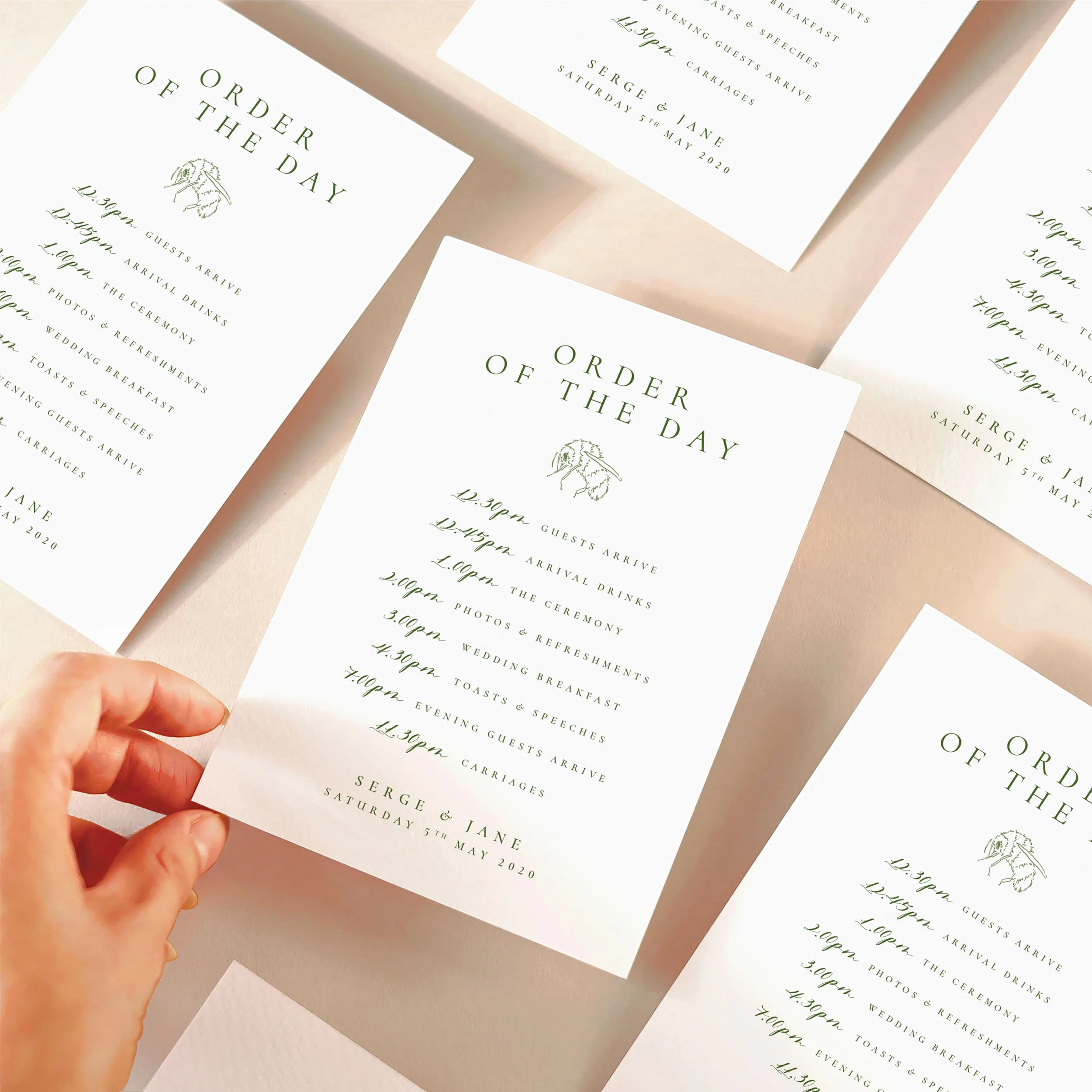 A hand picking up an order of the day timeline card with a green design featuring a bumble bee