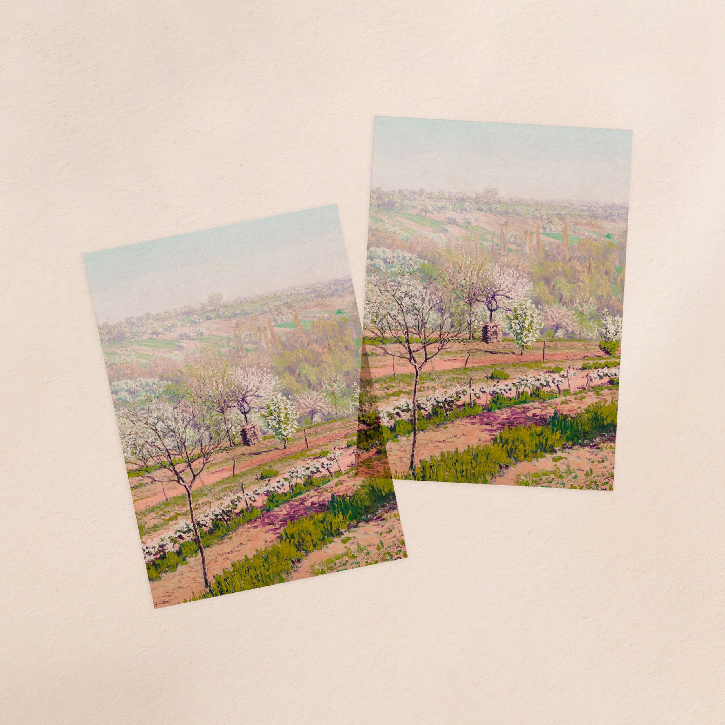 Two vellum paper overlay sheets with a printed pink and green landscape painting design