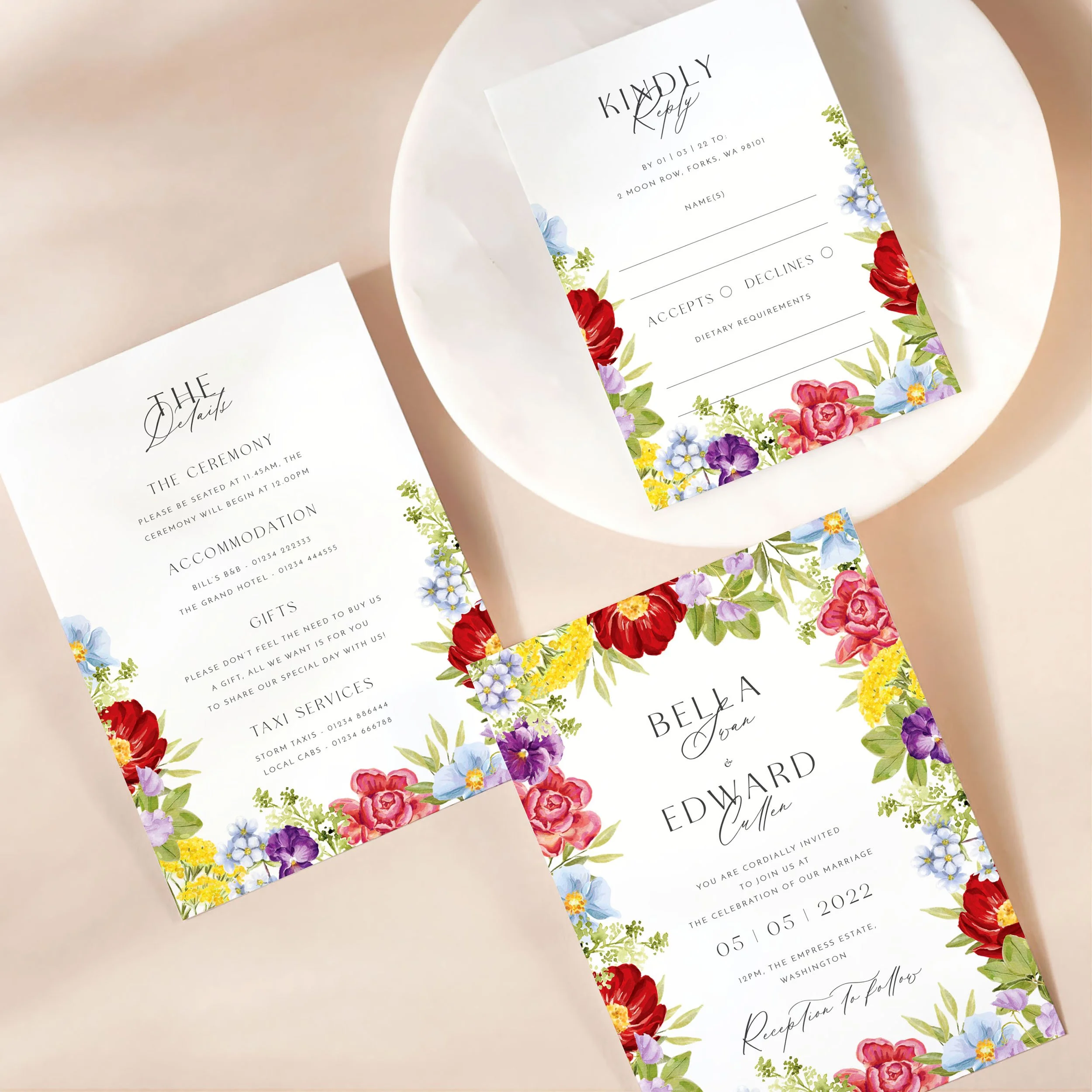 A wedding invitation card with details card and rsvp on a marble dish. There is a bright watercolour flower design on each card.