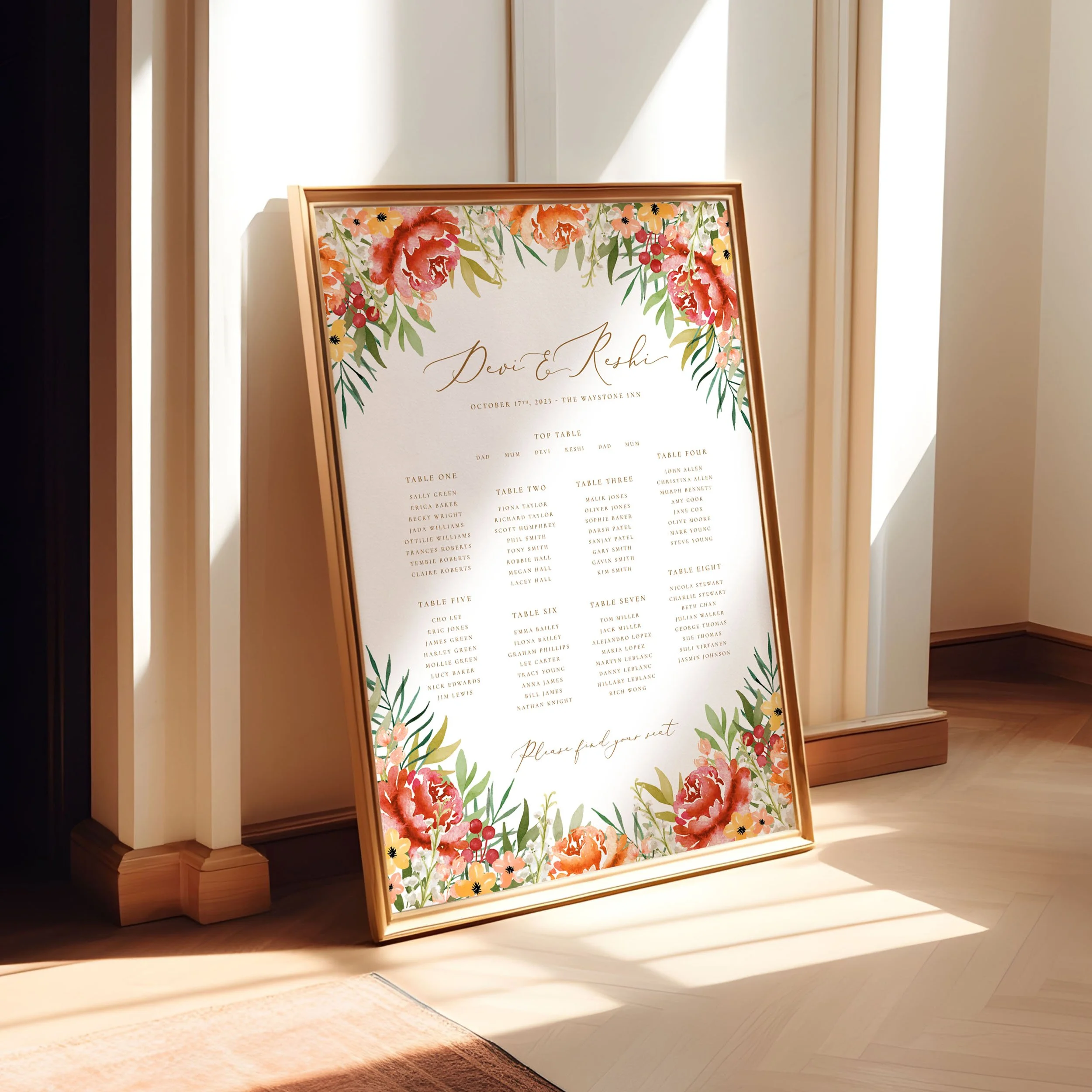 A framed A1 table plan sign leaning against a wall as the light spills across. The design has watercolour burnt orange flowers and green leaves.