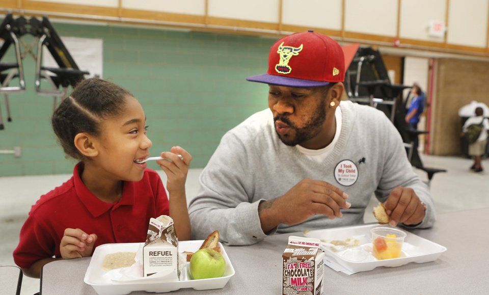 Below: Third-grader Gaybriana James and her dad, Gayland, eat breakfast Friday during Take Your Child to School Day at F.D. Moon Elementary School. Gayland James said he took off work to be there with his daughter.