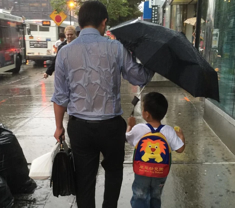 'Umbrella Dad' Gets Soaked In The Rain To Keep His Son Dry