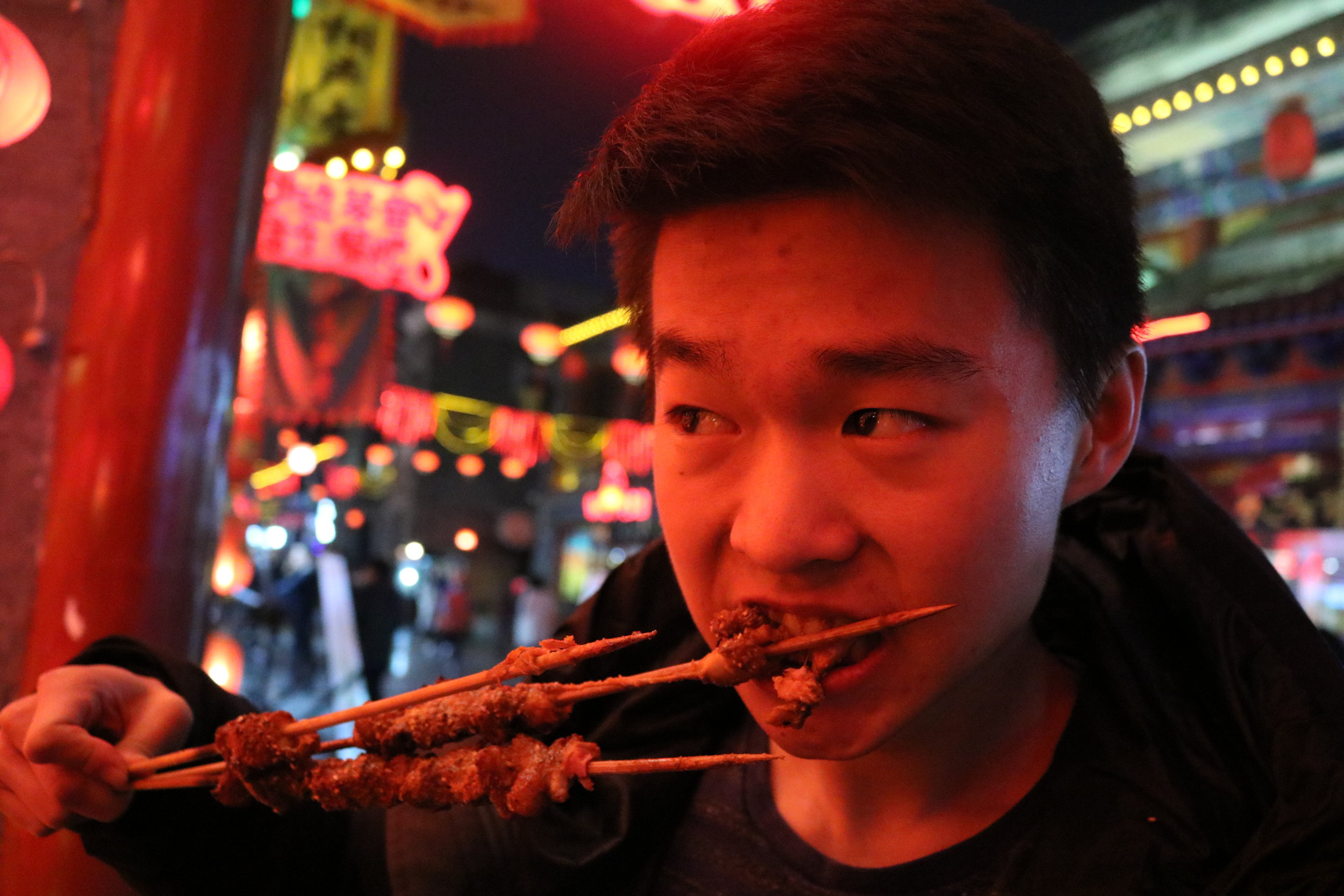  Tyler, ‘21, tries some meat skewers at a night market in Taiyuan 