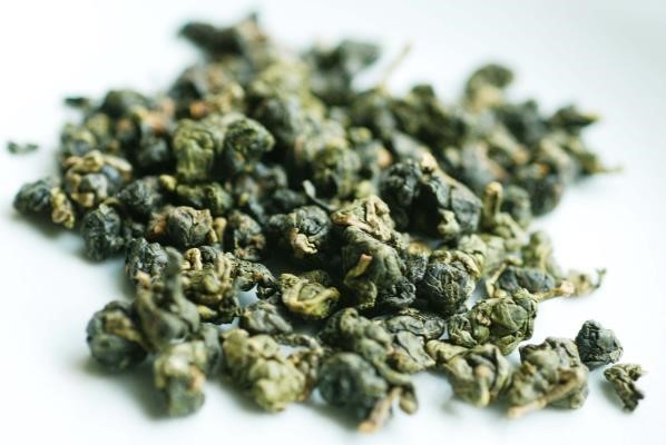 Close up of Oranic Minjian dark green rolled balled oolongs. 