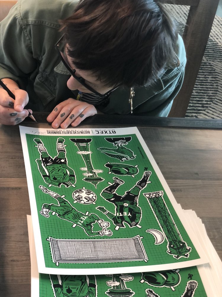 Artist signing printed poster