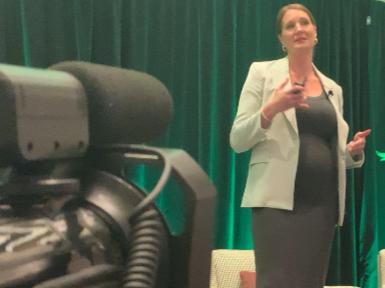 Global Glimpse CEO Eliza Pesuit speaking at the Indicultivate event as John Kind Studios records the presentation.