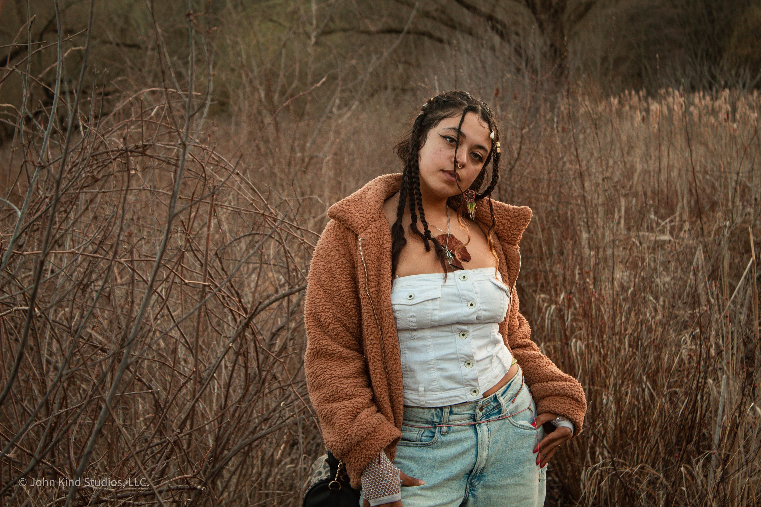 Artist Eva Davenport posing during an outdoor portrait session photographed by John Kind Studios.