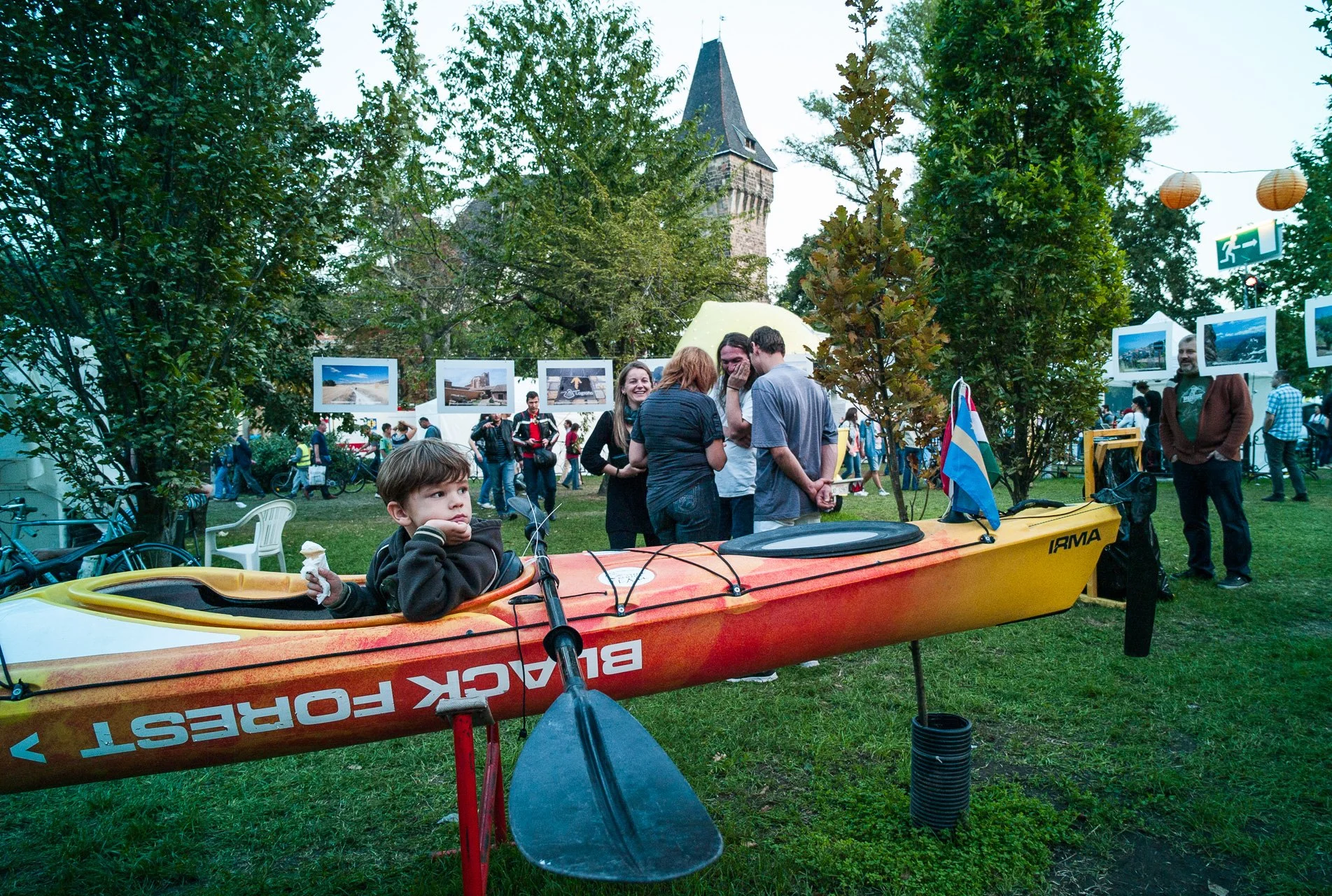 Boy daydreams in a show kayak at the Kürtőskalács Festival hosted on the Vajdahunyad Castle grounds.