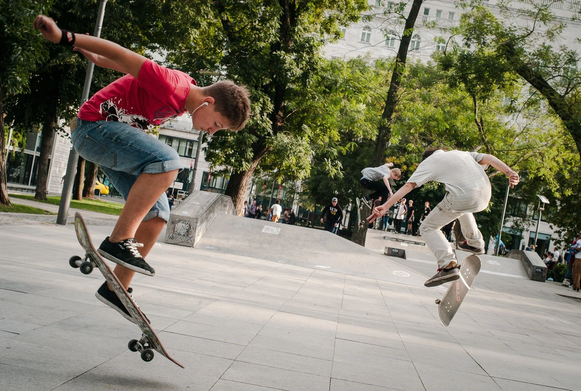 Three teenagers performing a trick in a local skateboard rink.