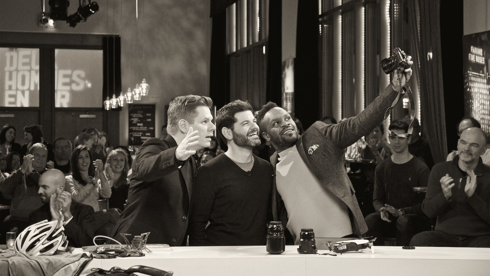 Jonathan B. Roy prend un égoportrait avec les animateurs sur le plateau de Deux hommes en or, devant le public qui applaudit