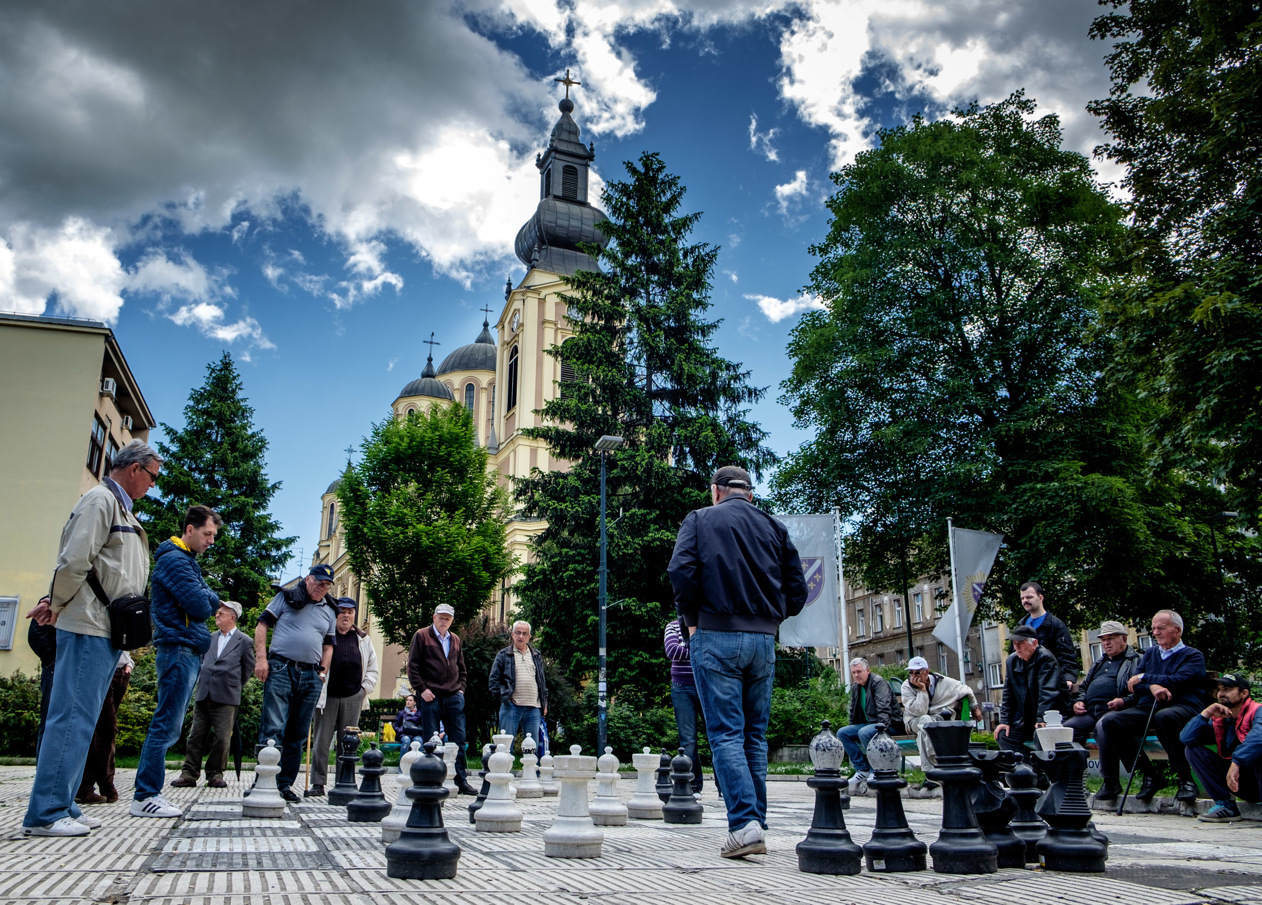 Pour deux hommes qui jouent aux échecs, vingt leur donnent des conseils.
