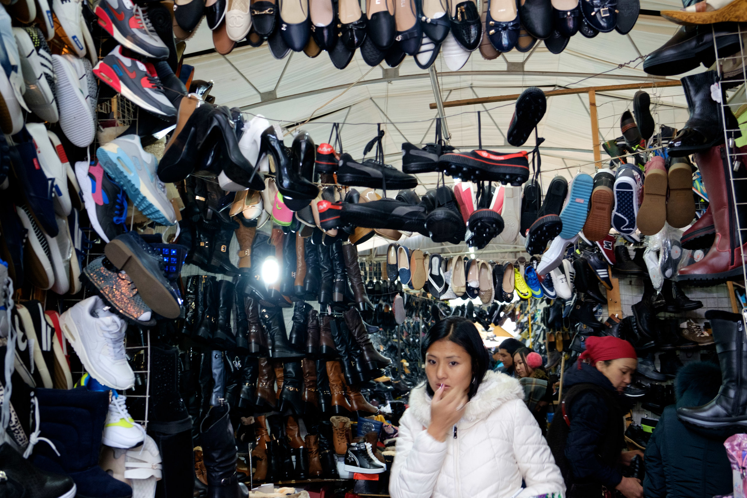 Une femme inquiète de ne pas trouver la paire de souliers parfaite dans ce bazaar.