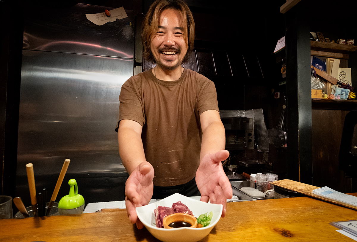 Taku, me montrant avec fierté la langue de cheval crue que je viens de commander dans son restaurant de Kobé. Bien qu’un peu musculeux, c’était quand même assez bon !