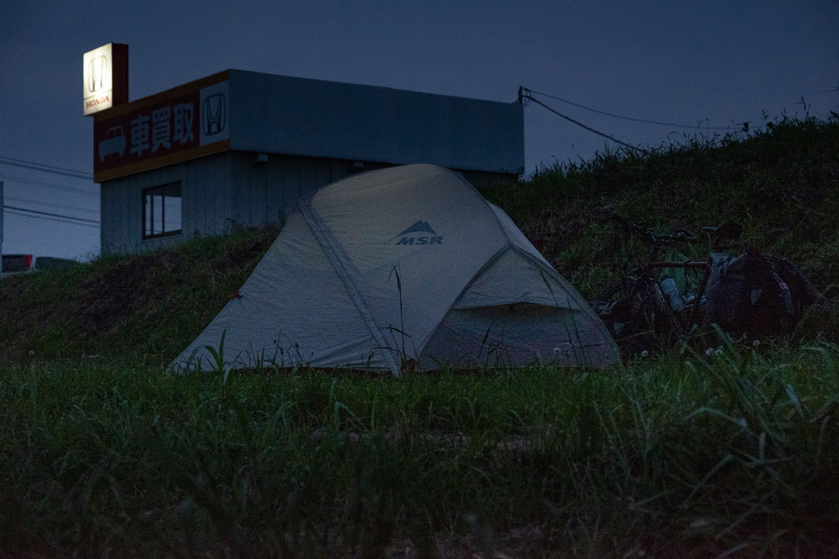 Camper dans la cour d’un concessionnaire automobile au Japon.
