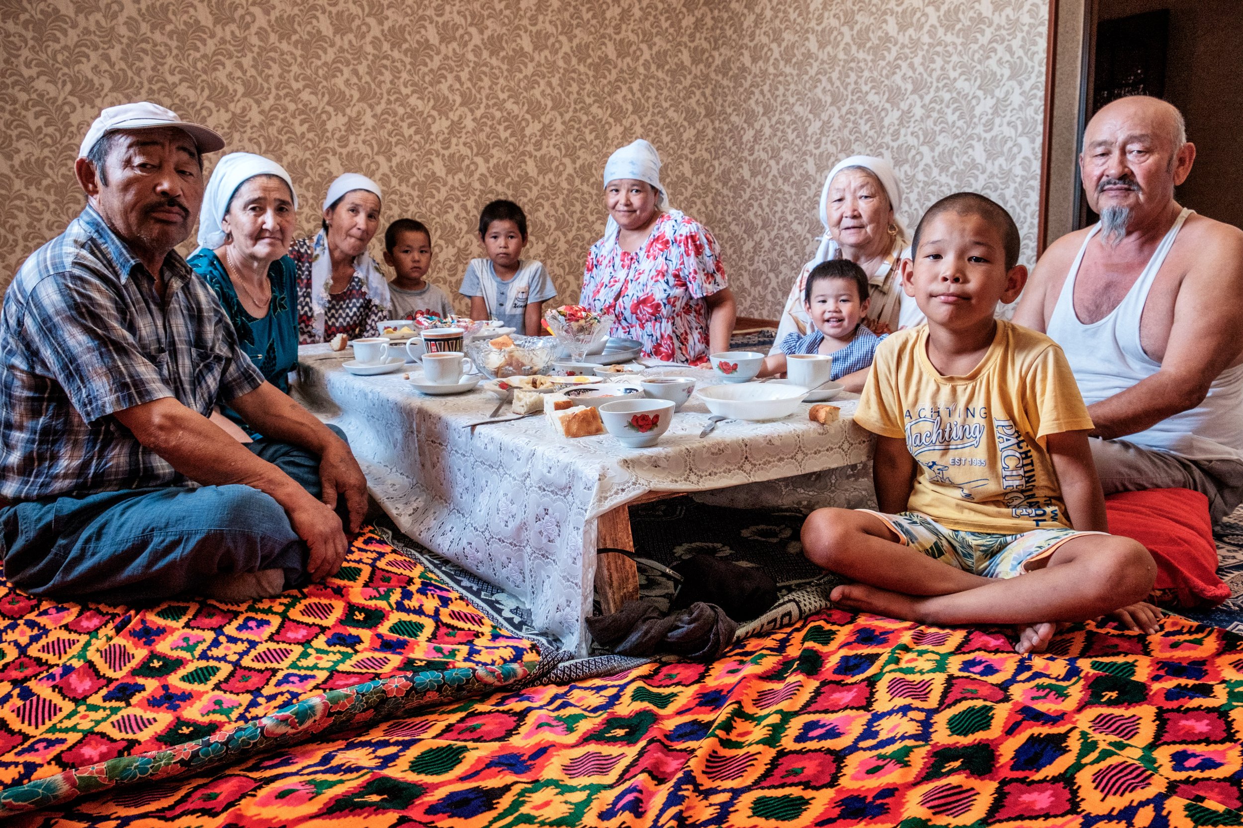 Une famille kazakhe autour d’un repas sur un tapis