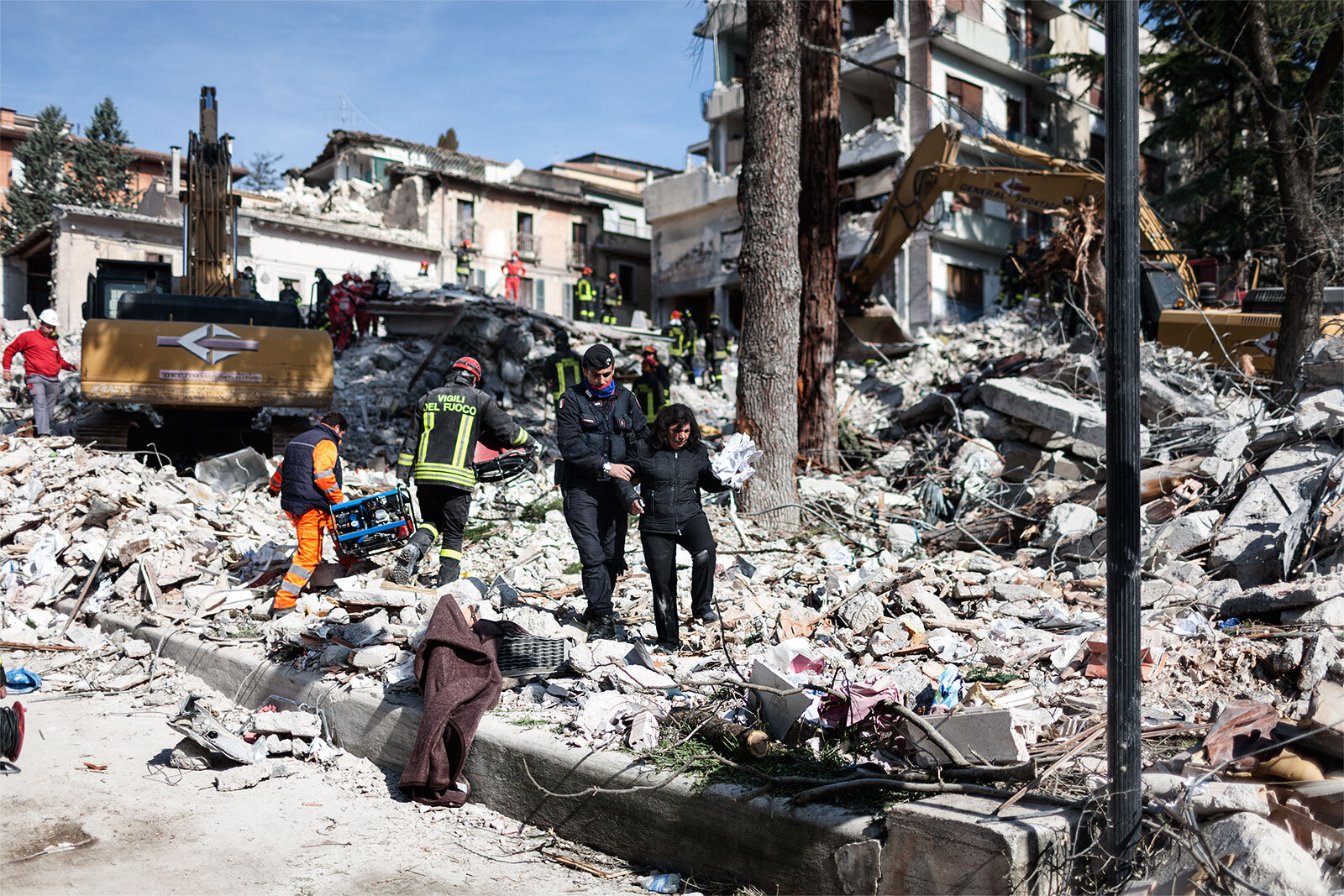  A Carabinieri officer helps a woman to walk over the debris of a building collapsed after a 6.3 Richter scale earthquake on Apr. 2009 in L’Aquila, Italy. 