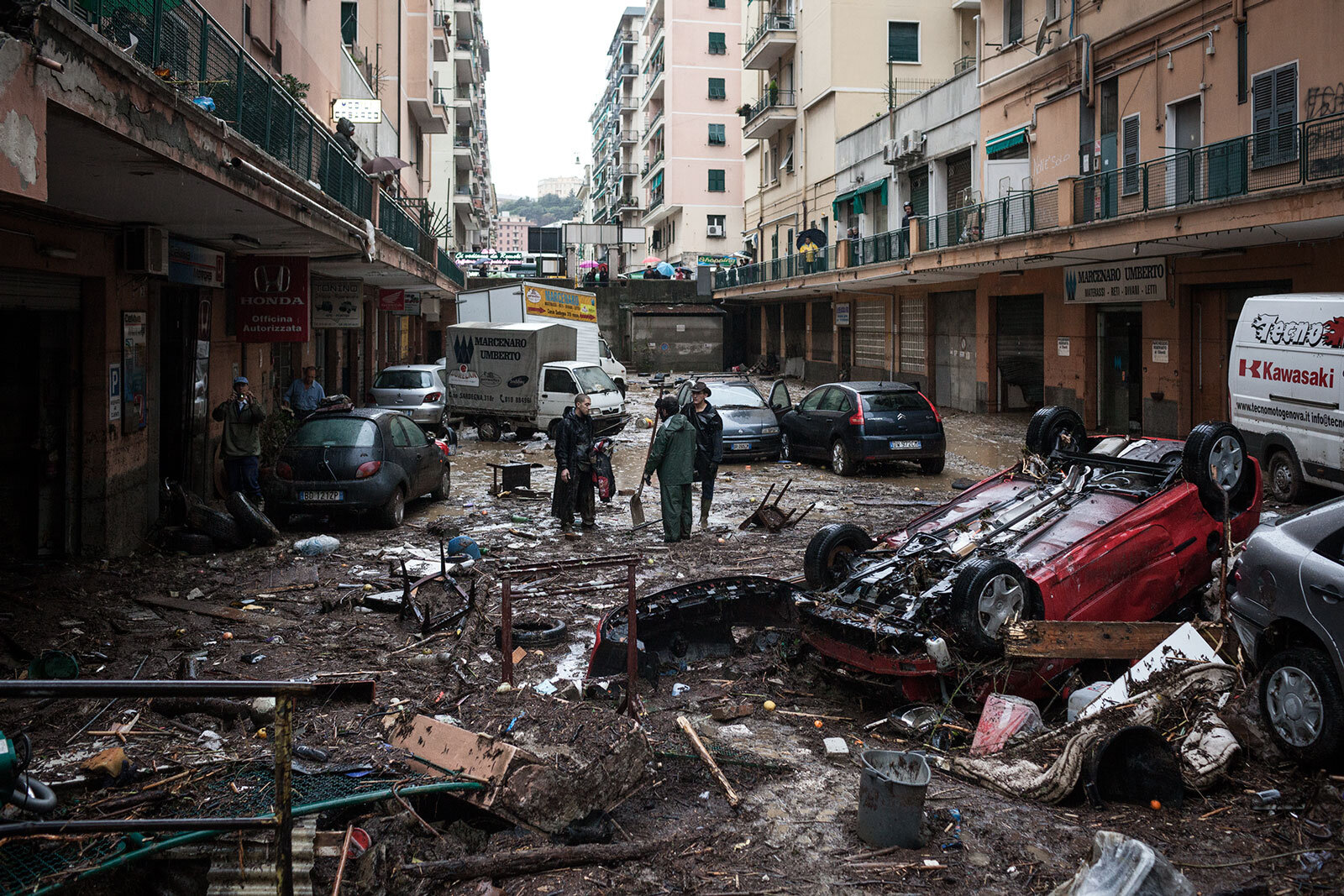  People stand in a street ravaged by flood from tropical storm - like heavy rainfall on Nov. 2011 in Genoa, Italy. 