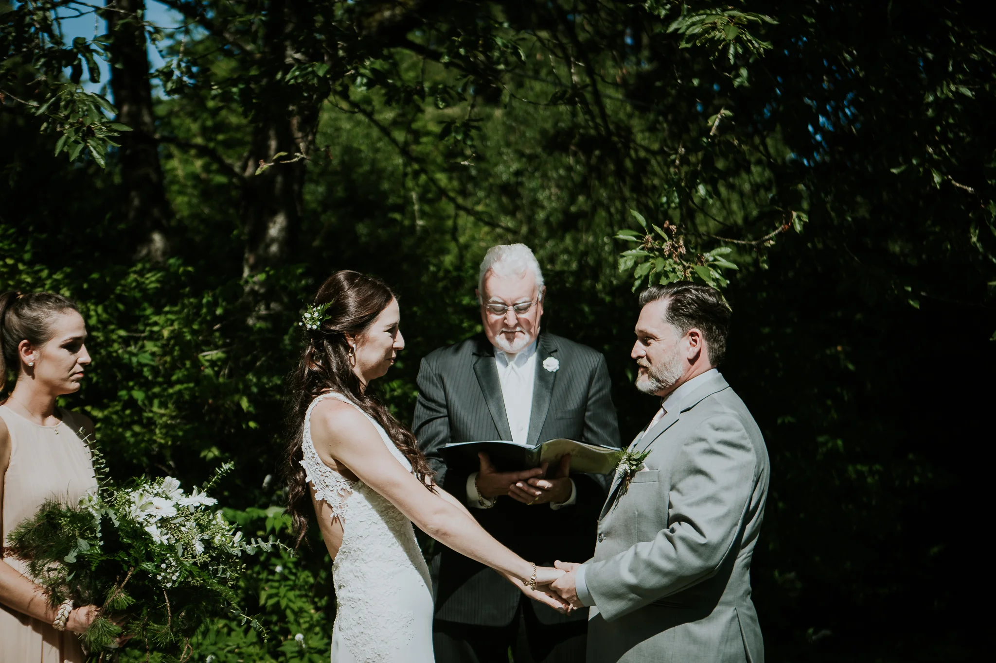 Bride and groom holding hands during ceremony at Starling Lane winery